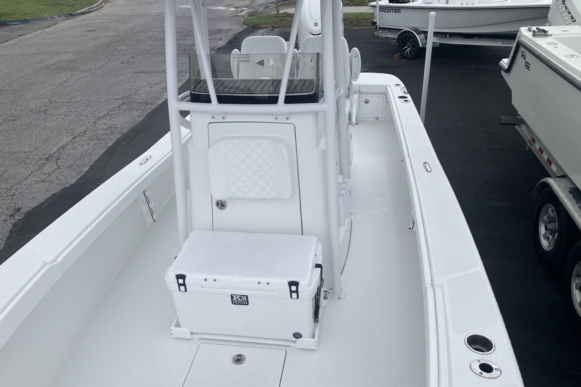 2026 BlackJack 256 Coastal boat interior with console and seating, parked on pavement.