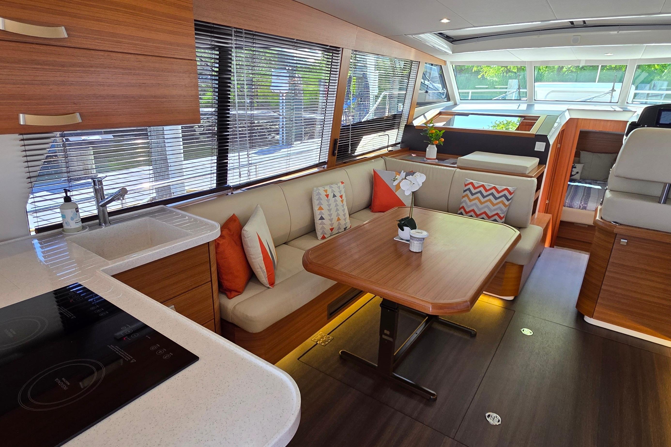 Luxurious interior of 2023 Greenline 40 yacht with modern kitchen and cozy seating area.