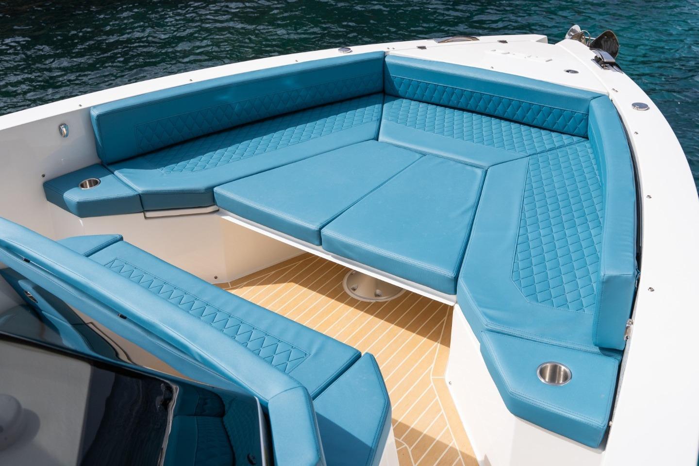 Luxurious seating on 2026 De Antonio Yachts D29, featuring blue upholstery and cup holders.