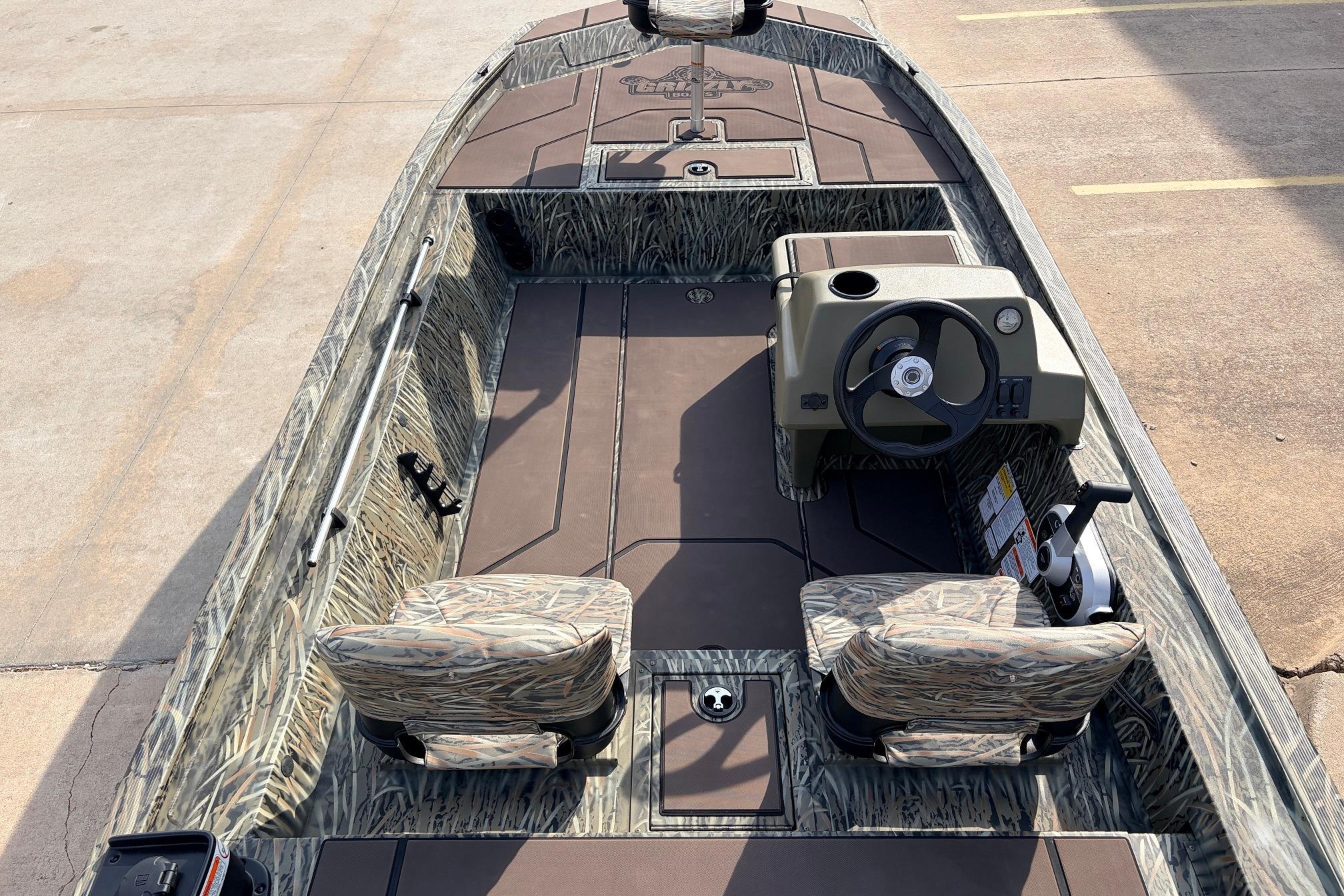 2026 Tracker Grizzly 1754 SC boat interior with camouflage seats and steering console.