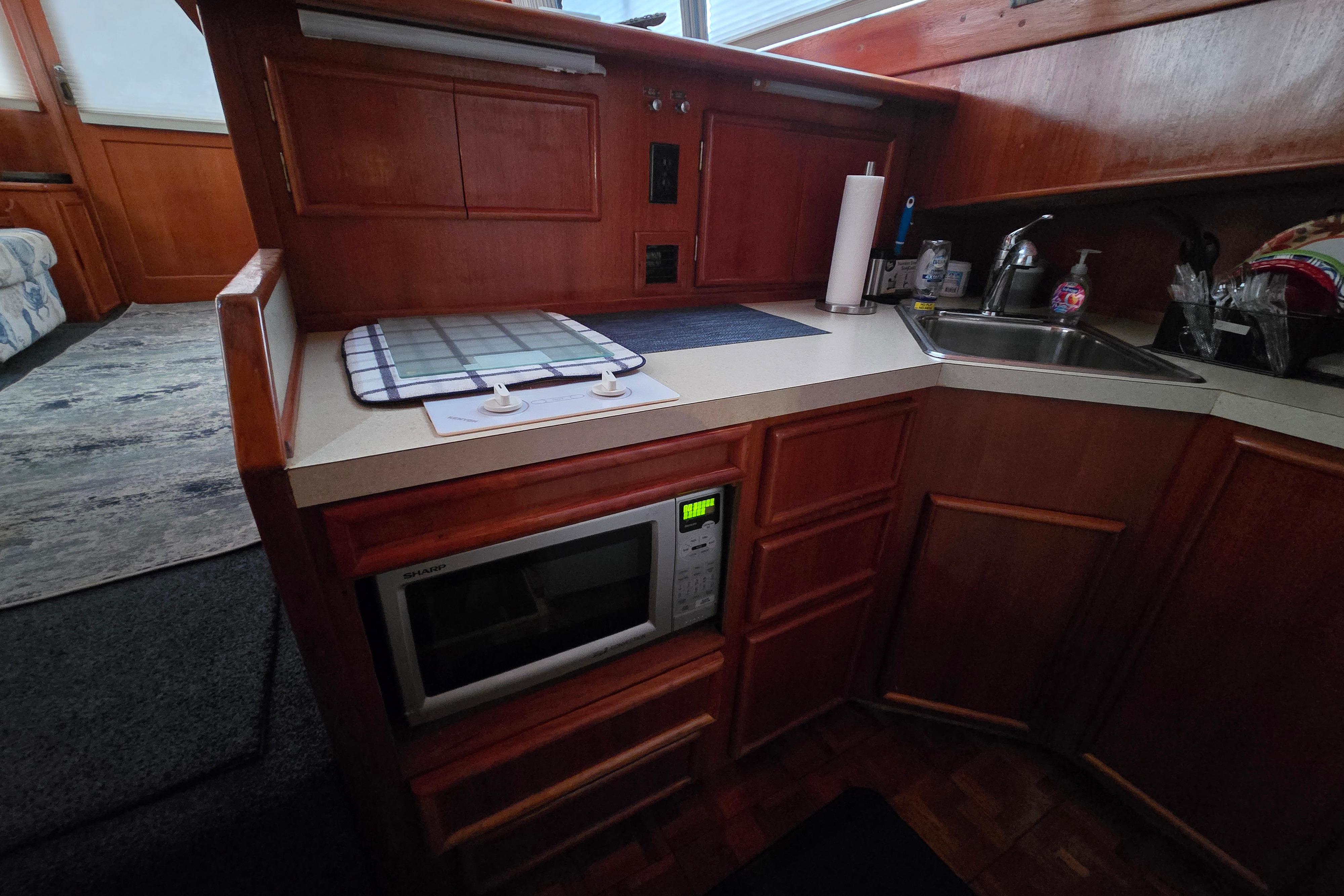 1988 Post 46 Convertible yacht kitchen with microwave, sink, and wooden cabinetry.