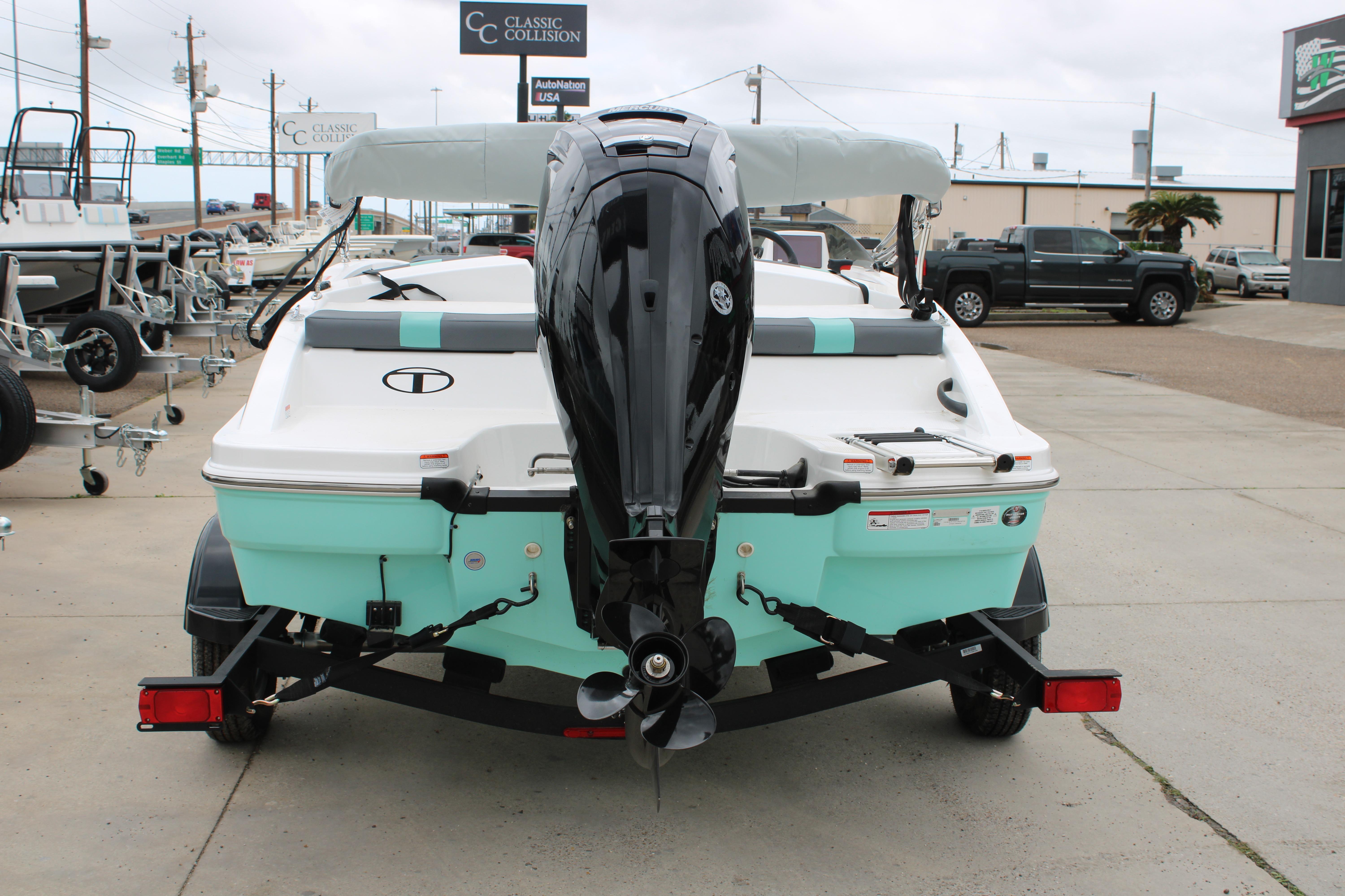 2026 Tahoe T16 boat with outboard motor on a trailer, parked outdoors.