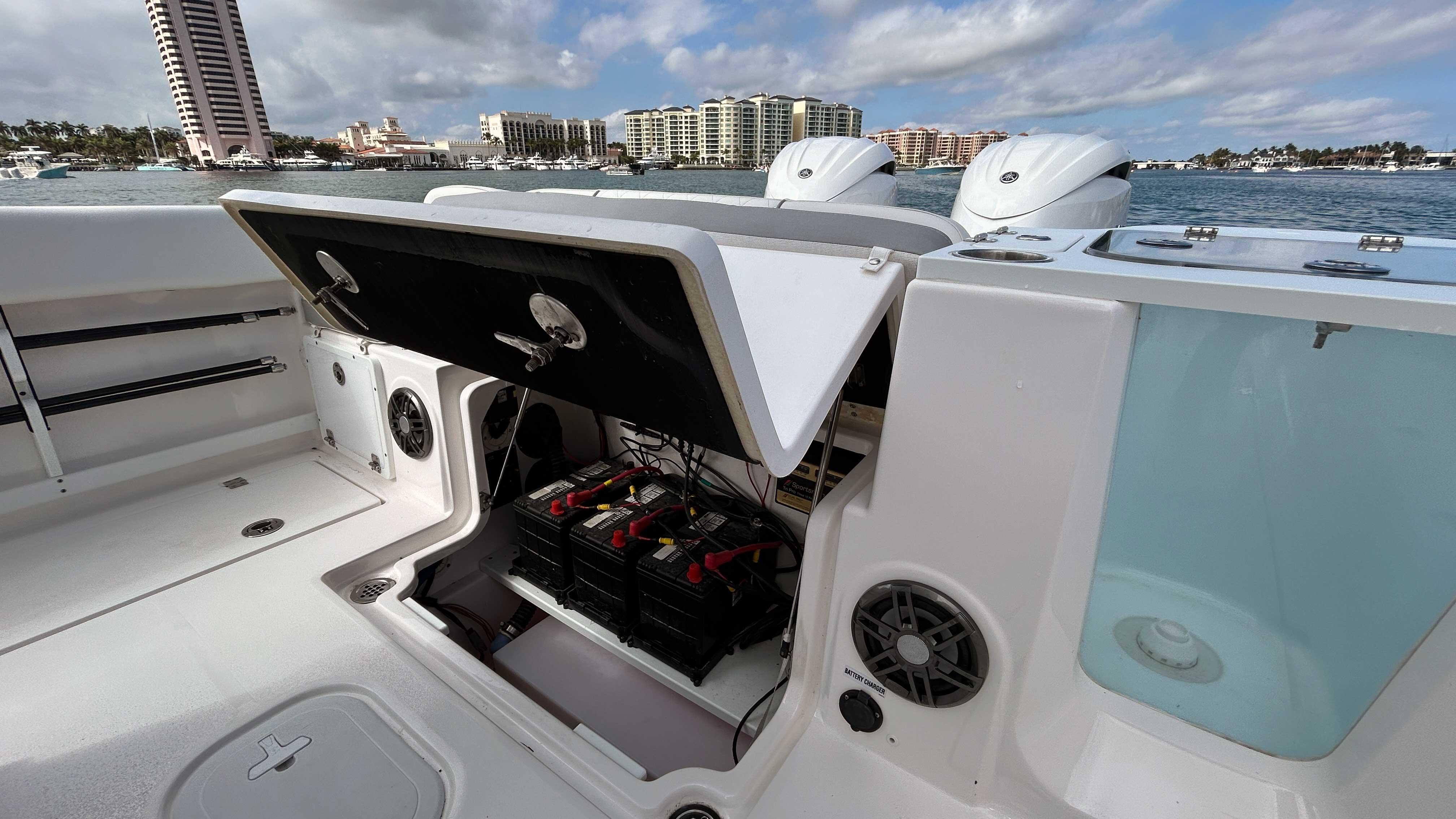 2024 Sea Fox 268 Commander boat with open storage compartment, docked near waterfront buildings.