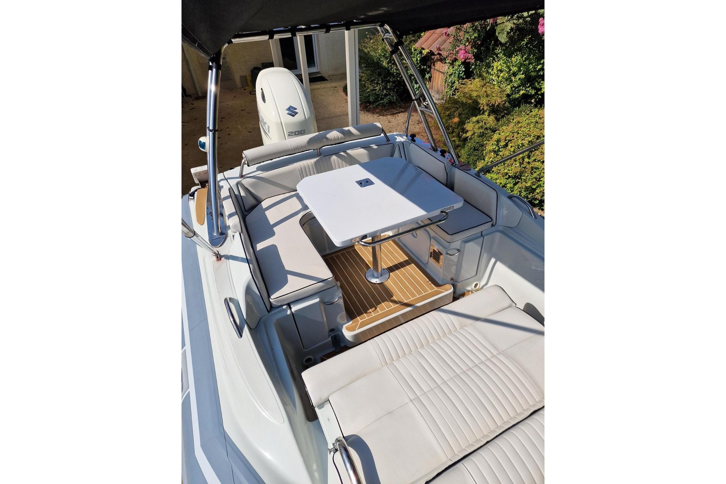 2019 Zar Formenti Zar 65 boat interior with seating and table, featuring Suzuki engine.