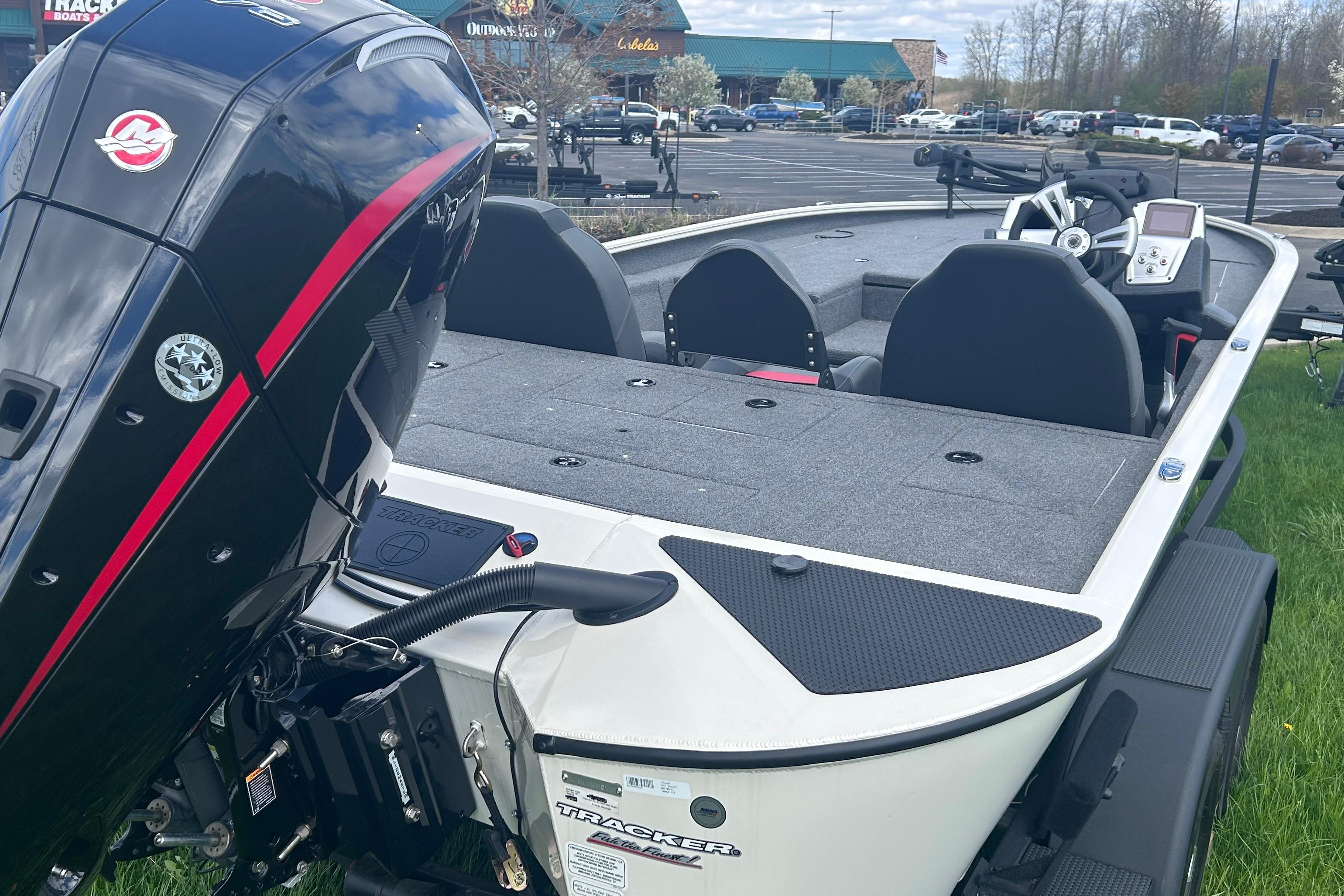 2025 Tracker Savage 215 boat with powerful outboard motor, parked outdoors.
