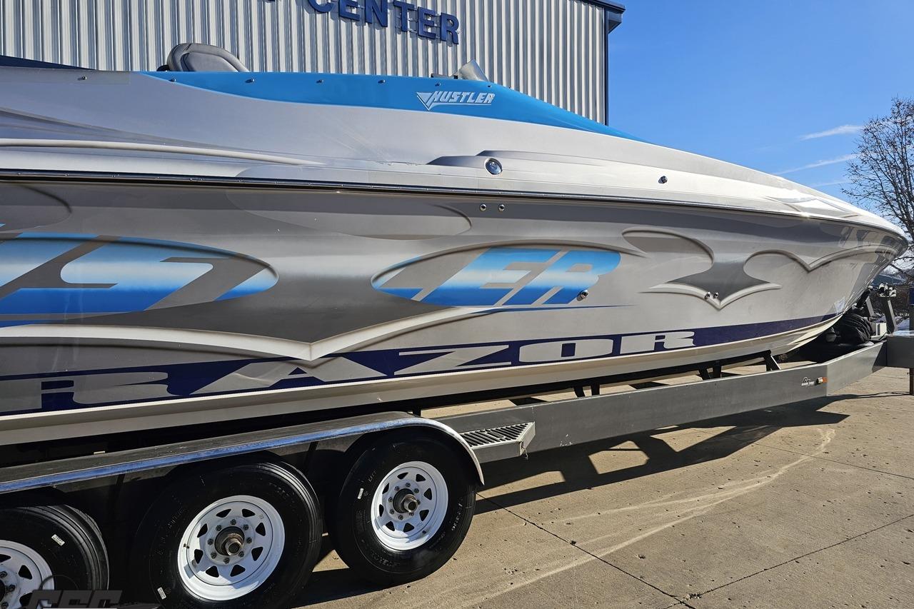 2007 Hustler 41 Razor boat on trailer, sleek design, parked outdoors.