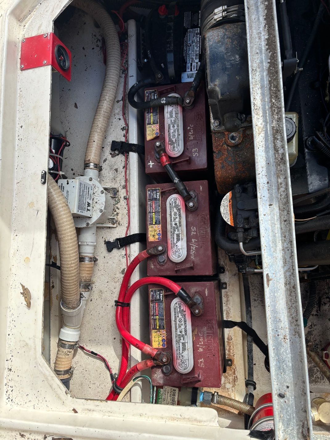 Battery compartment of a 1997 Donzi 275LXC boat with cables and hoses.