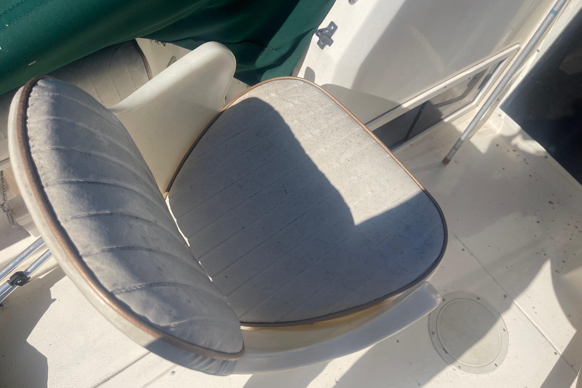 Boat seat on a 2000 Seamaster 2388 WA, featuring white upholstery and green cover.