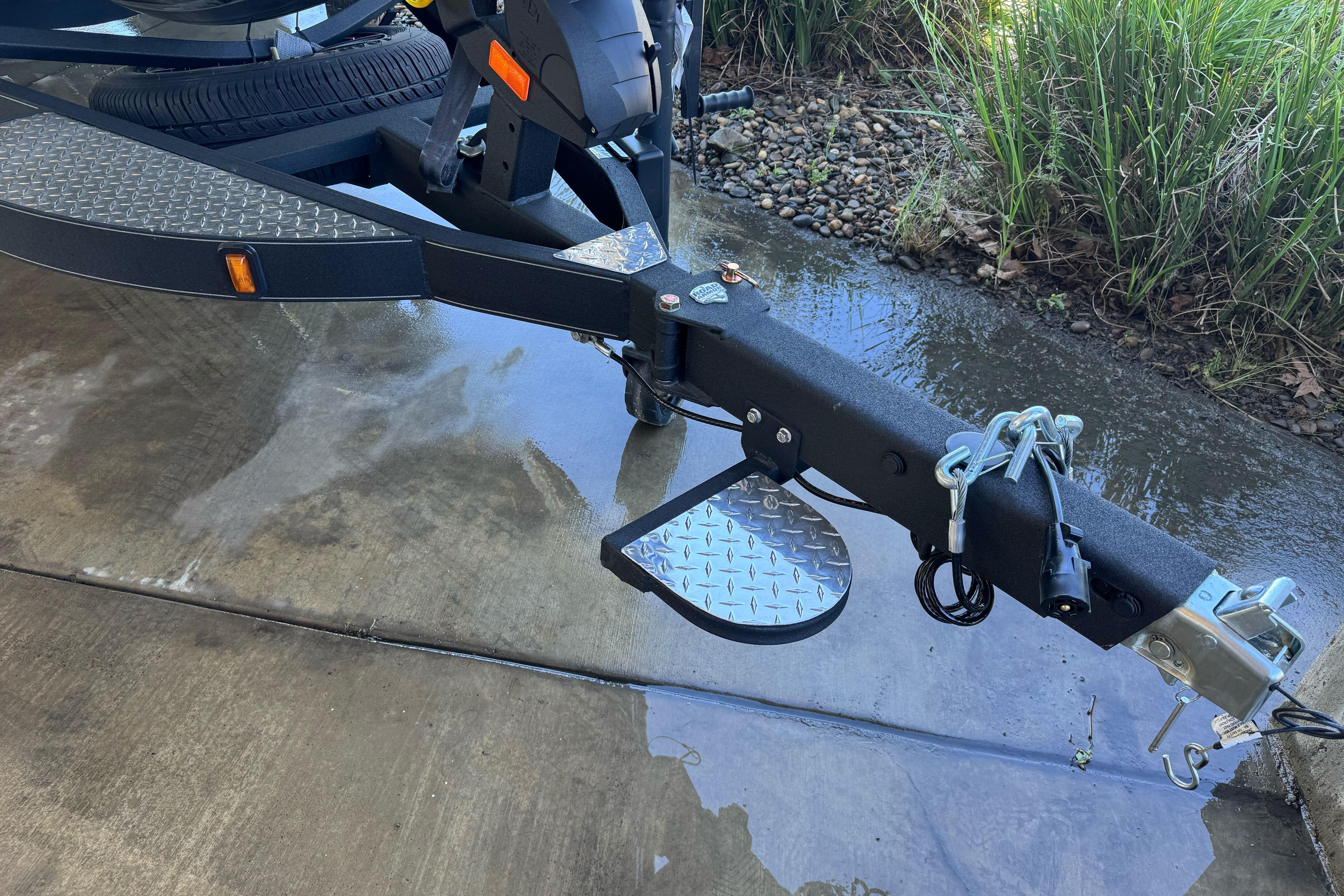 Trailer hitch of 2026 Triton 21XP Patriot on wet pavement.