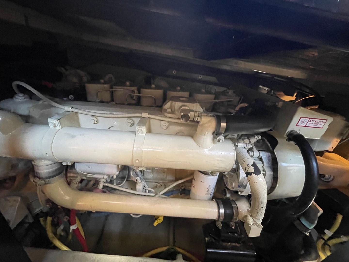 Engine compartment of a 2004 Meridian 459 Motoryacht, showcasing mechanical components and piping.