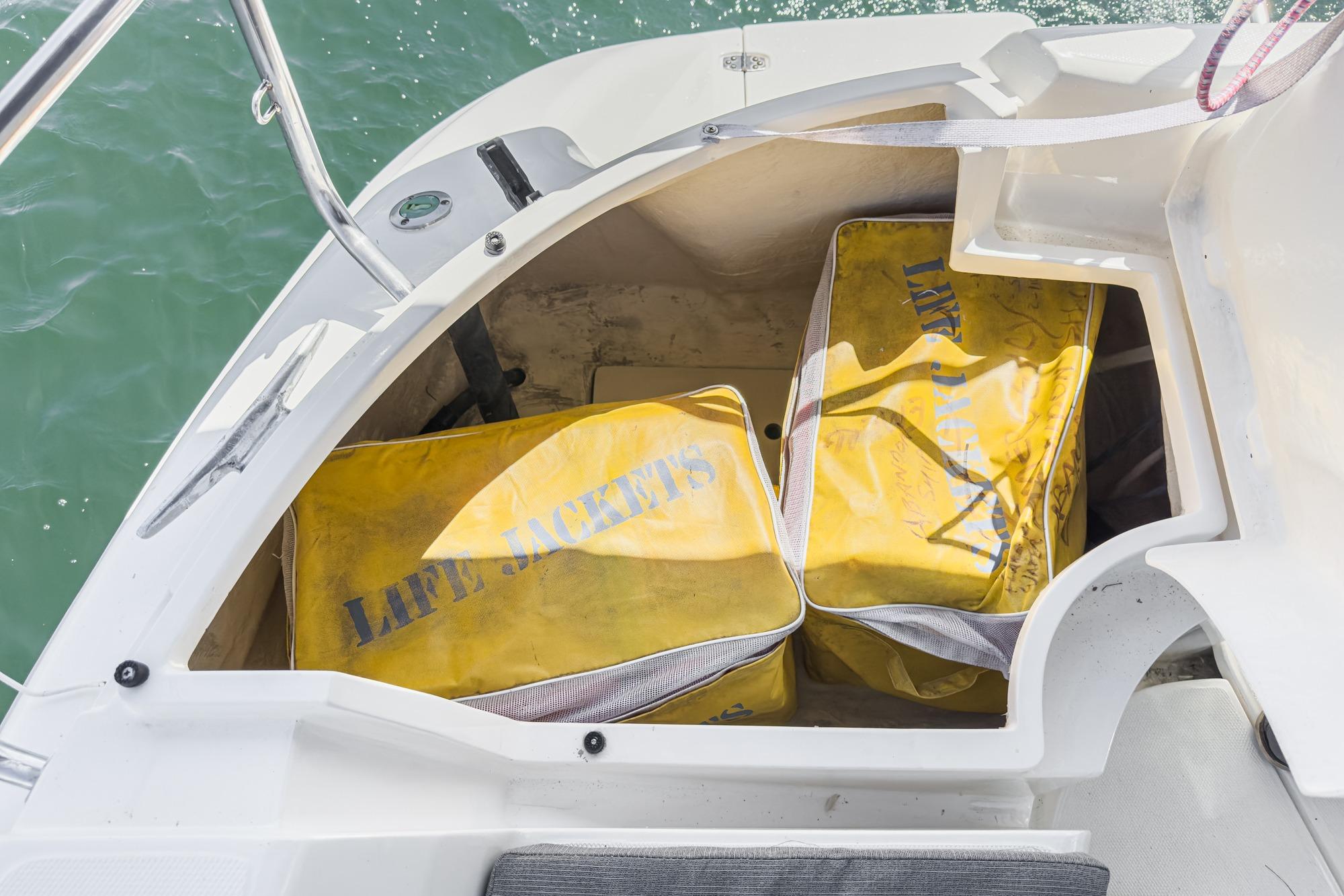 Yellow life jacket bags stored on a 1996 Hunter 376 sailboat deck compartment.
