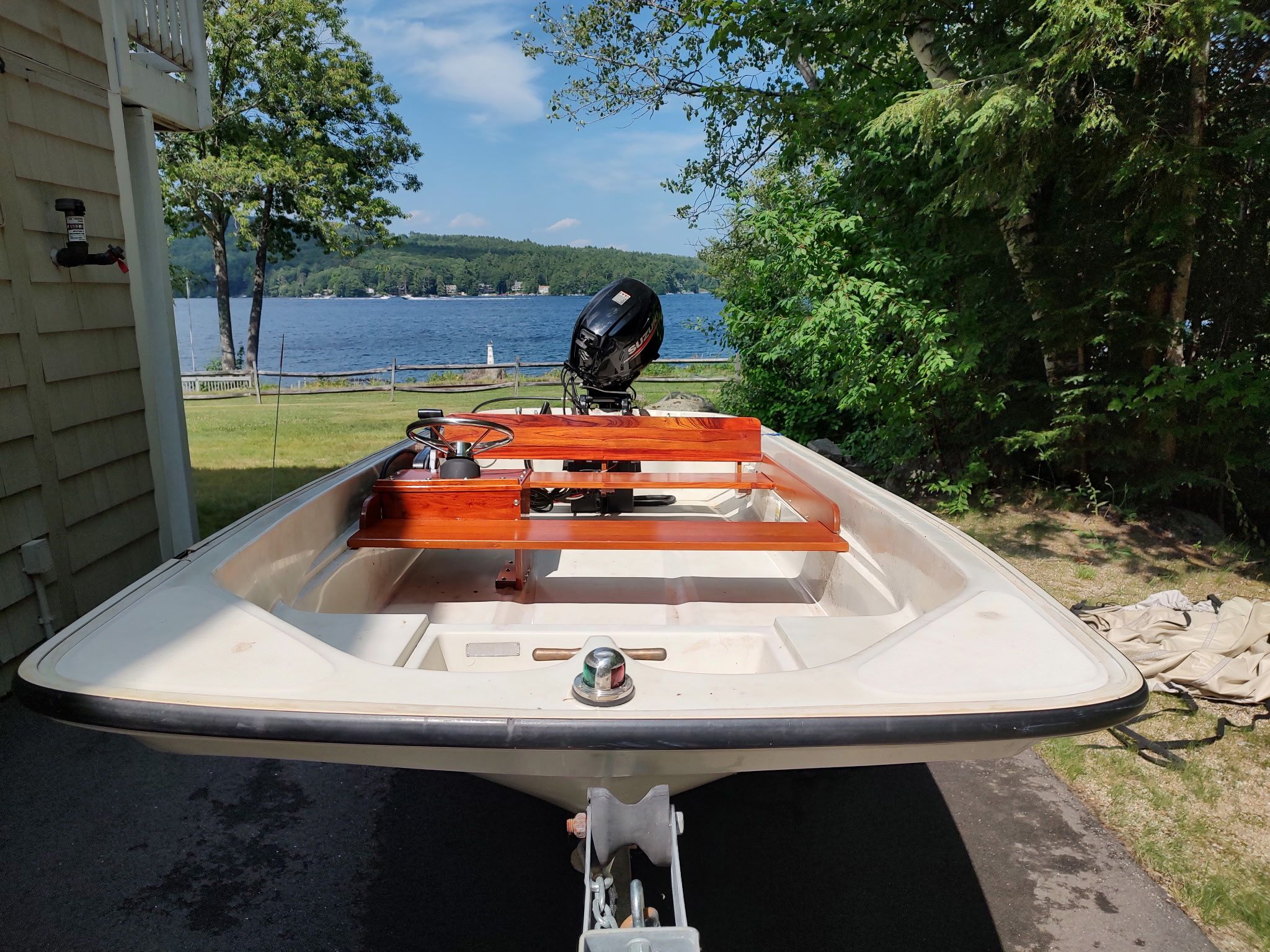 A 1987 Boston Whaler Sport 13 on a trailer. A lake is visible in the background.