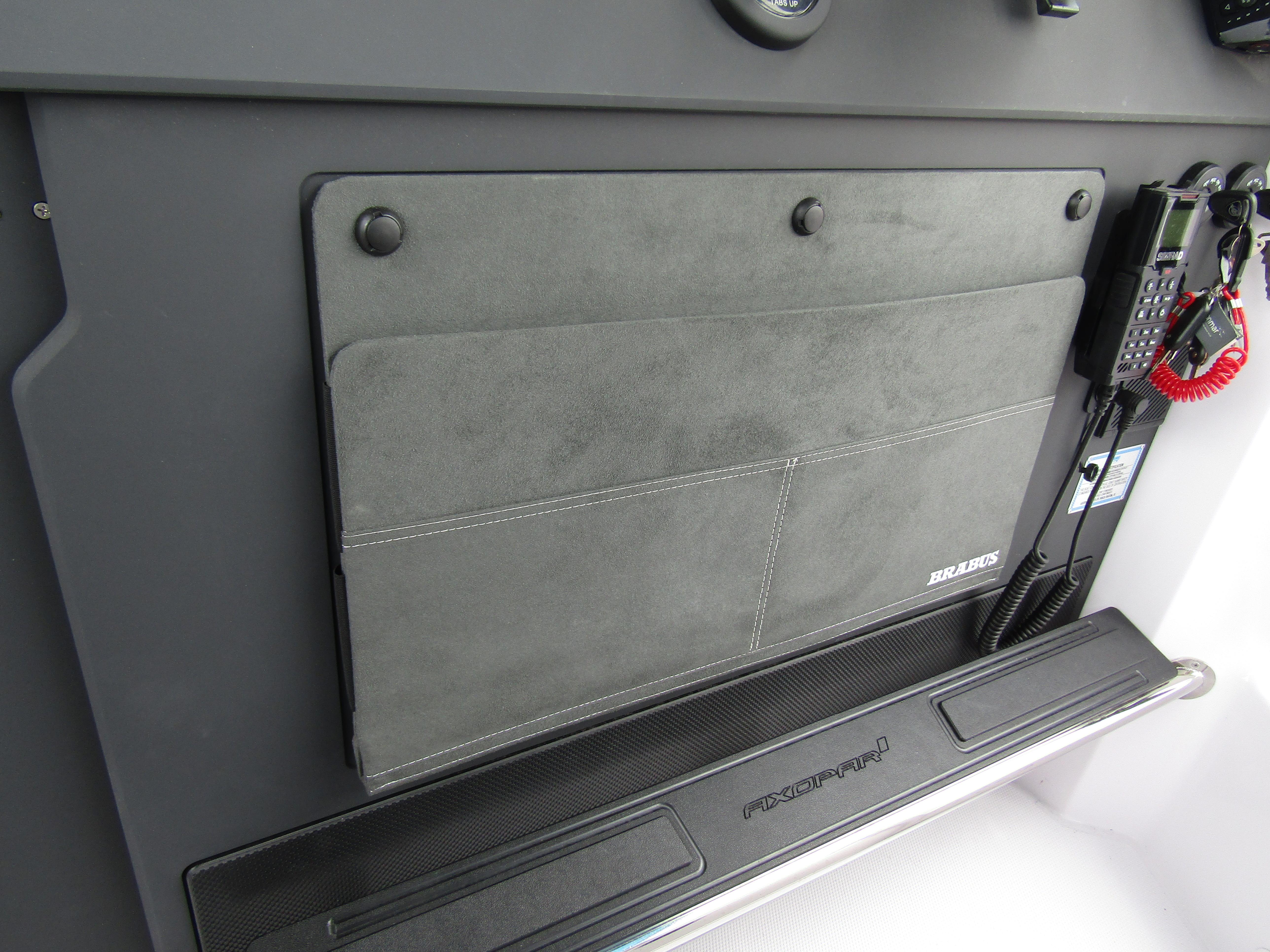 2024 Axopar 37 Sun Top dashboard with storage compartment and communication equipment.