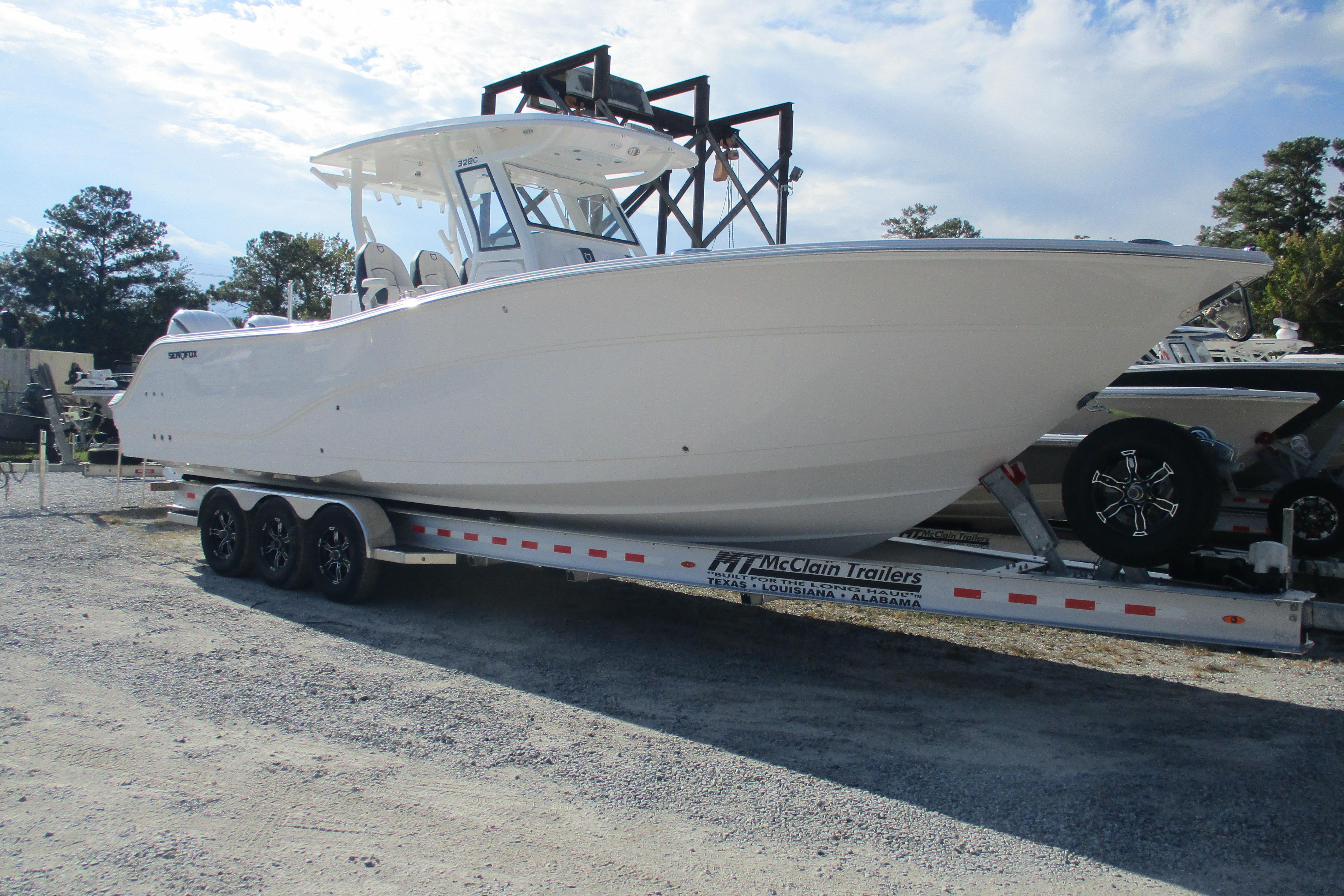 2026 Sea Fox 328 Commander boat on trailer, parked outdoors under a cloudy sky.
