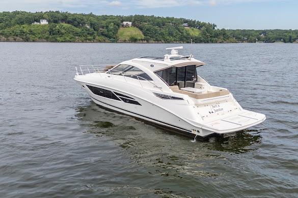2016 Sea Ray Sundancer 510 yacht cruising on a serene lake with lush green shoreline.