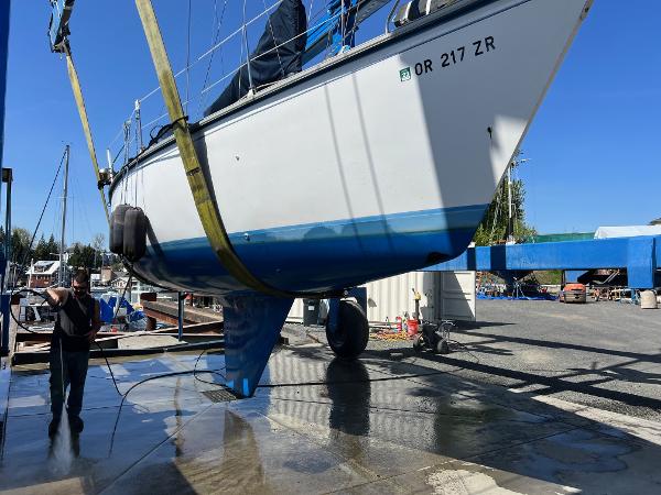 1984 Hunter 31 sailboat being lifted for maintenance at a marina.