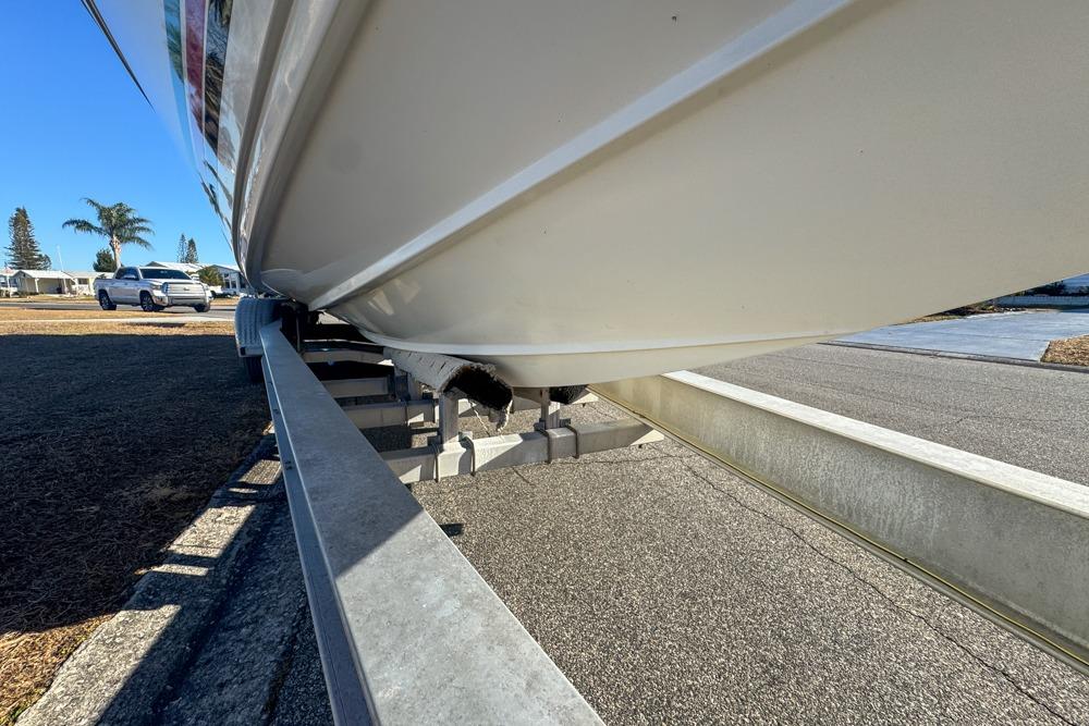 1989 Formula 292 SR-1 boat on trailer, side view, sunny day, palm trees in background.