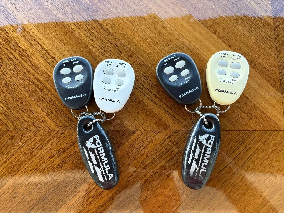 Two remote controls for a 2011 Formula 45 are placed on a wooden surface.