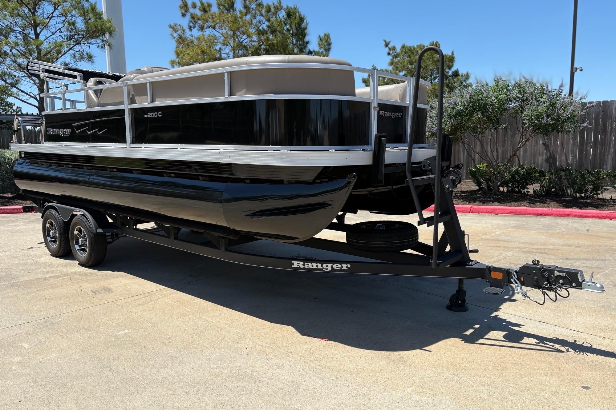 2024 Ranger Reata 200C pontoon boat on trailer, parked outdoors.