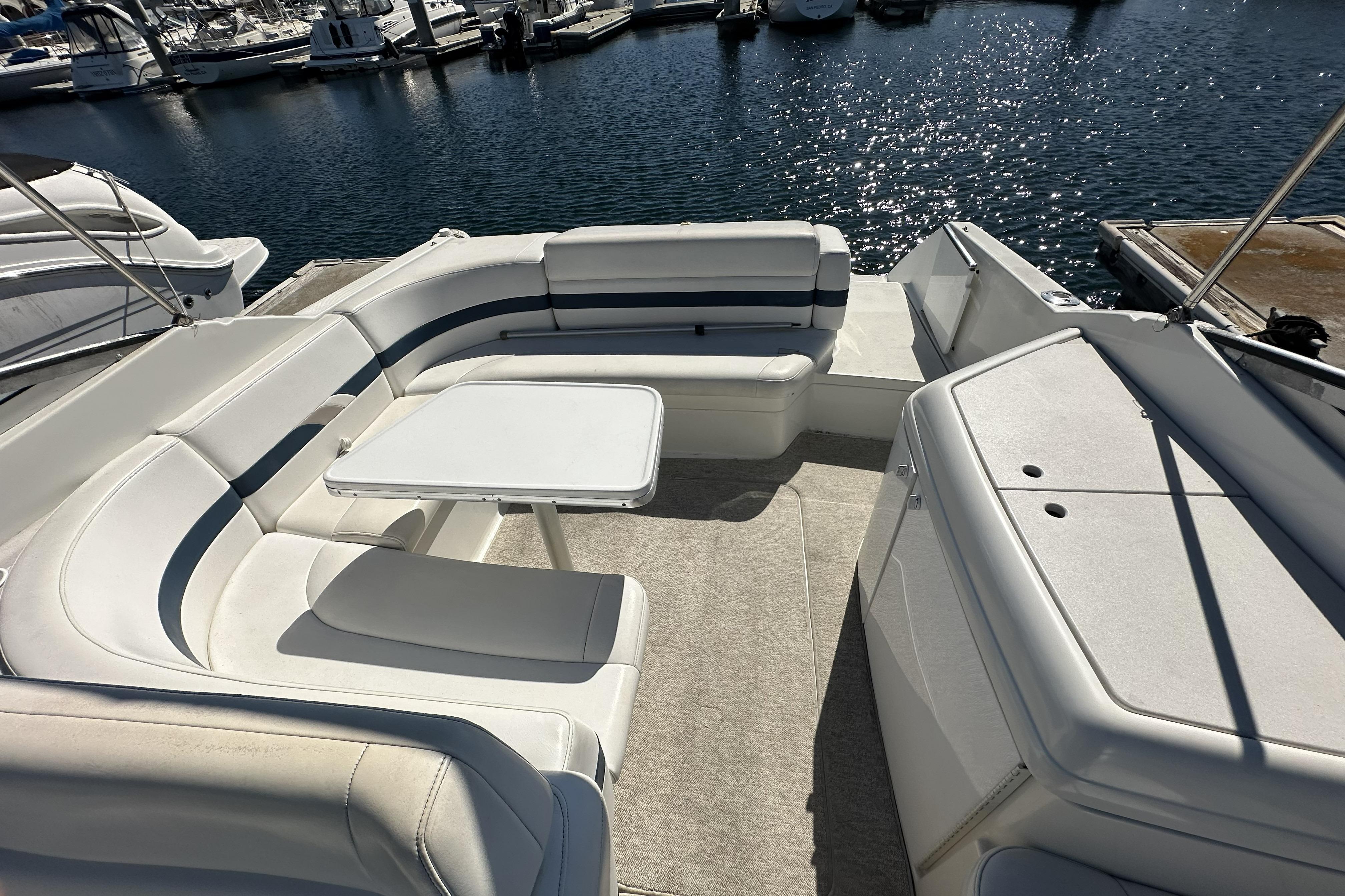 Spacious seating area on a 2000 Formula 280 Sun Sport boat docked at a marina.