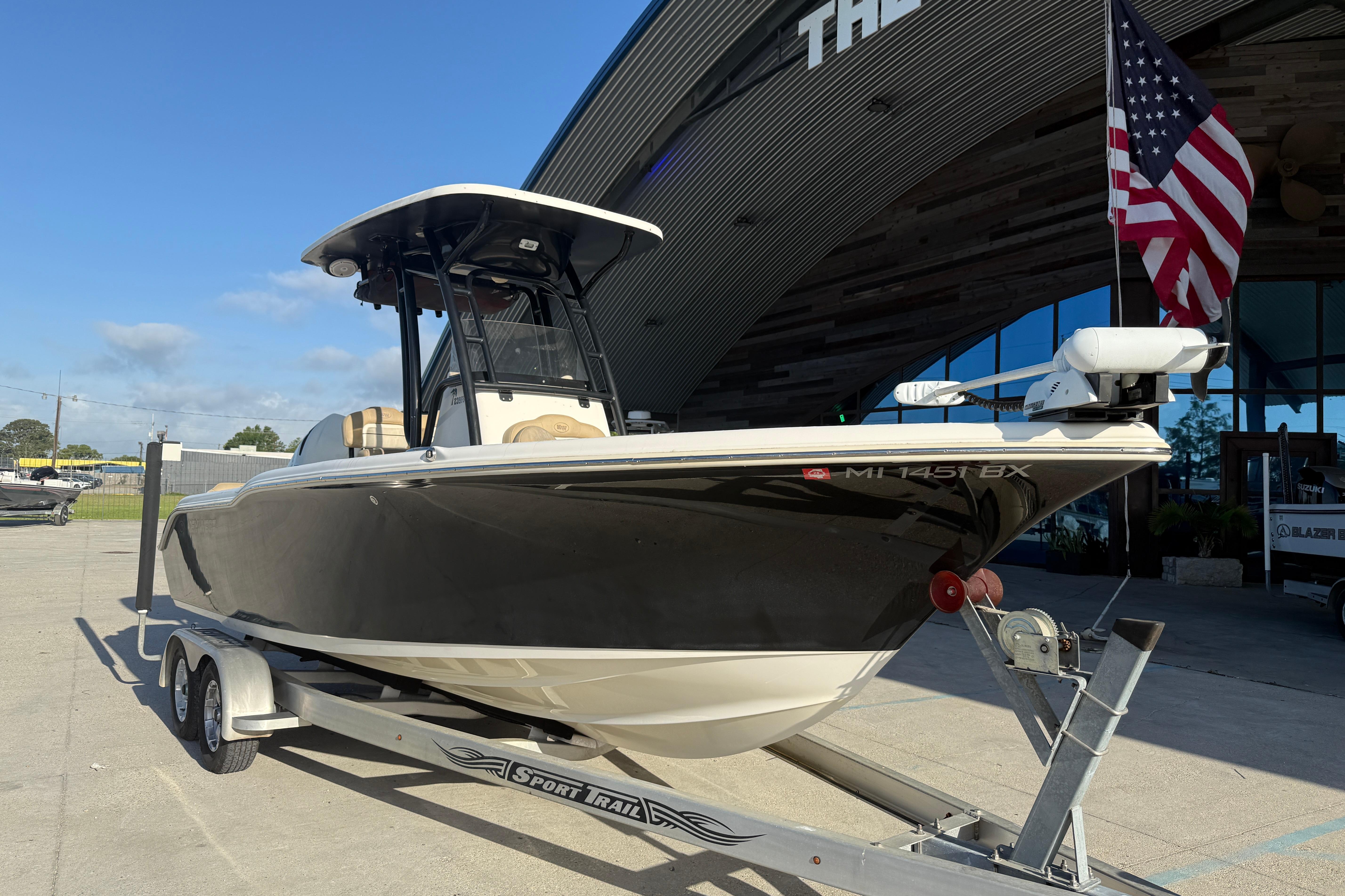 2016 Key West 239 FS boat on trailer, American flag, sunny day.