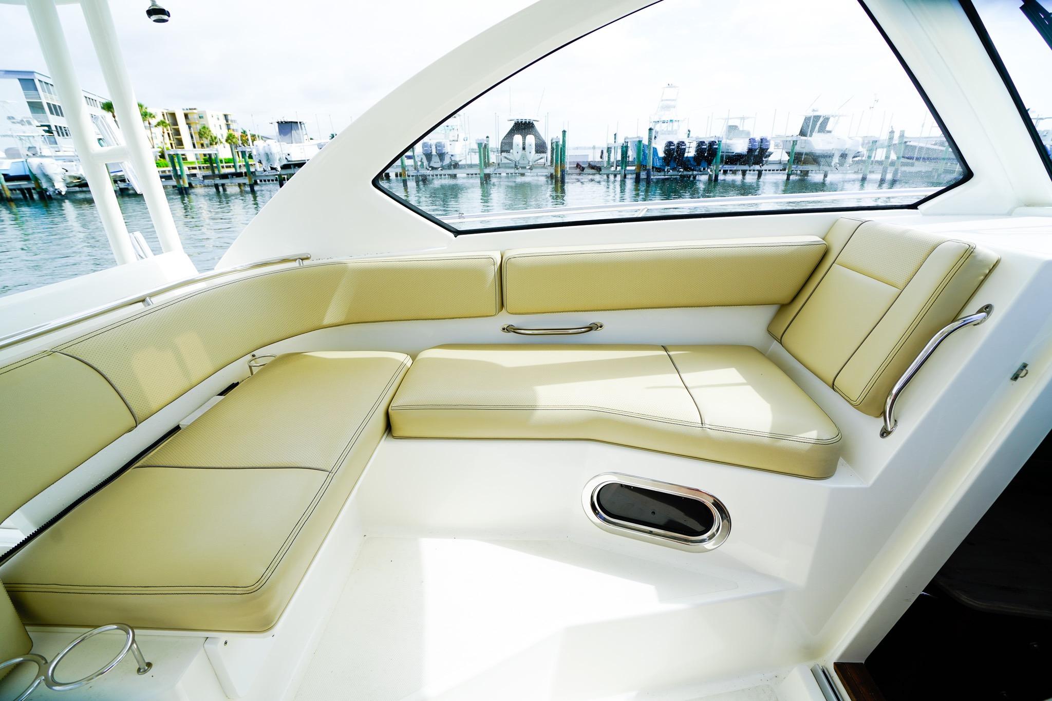 Luxurious seating area on 2020 Pursuit OS 325 Offshore boat, docked at marina.