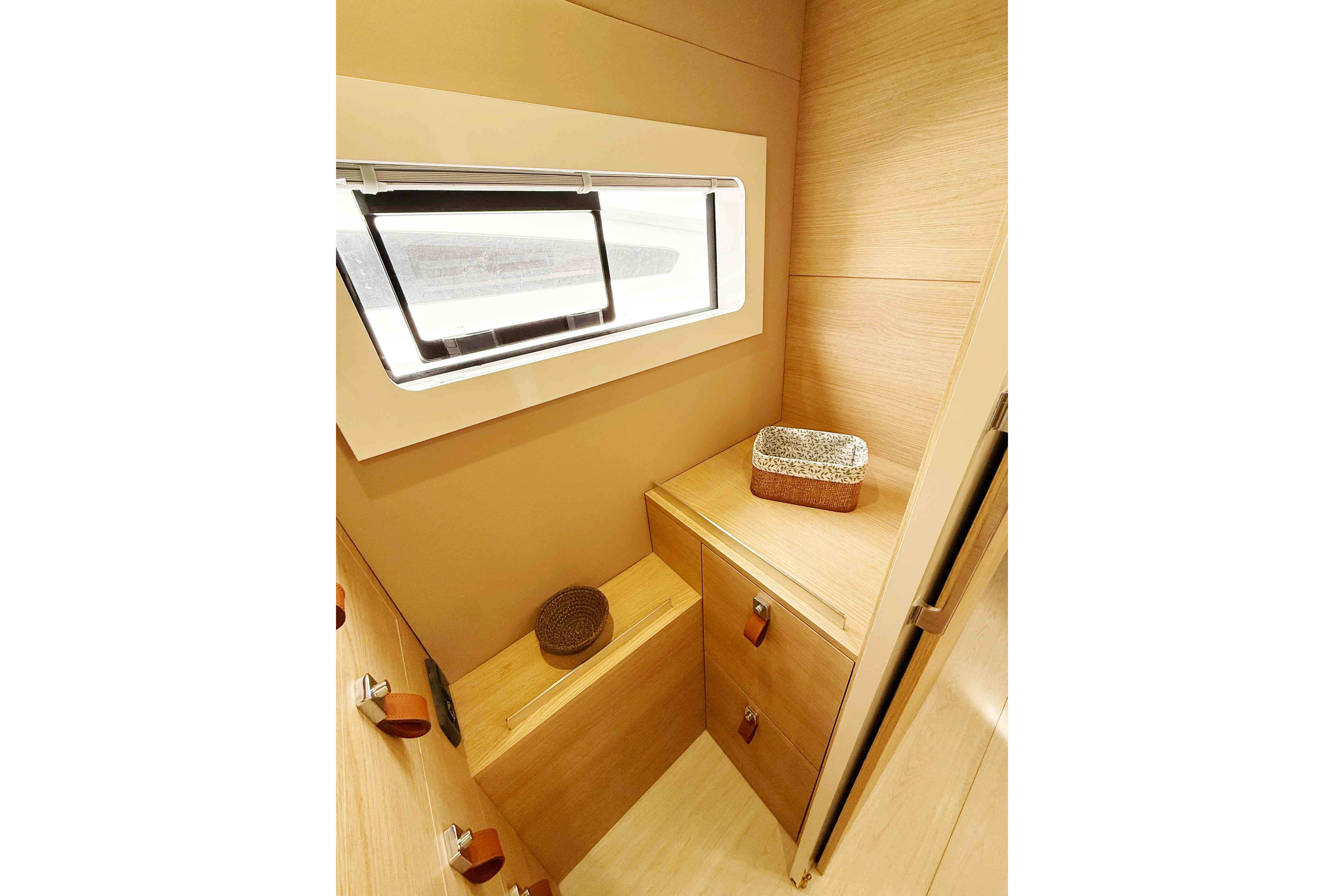 Interior of 2026 Aventura 37 Explorer Trawler with wooden cabinetry and window.