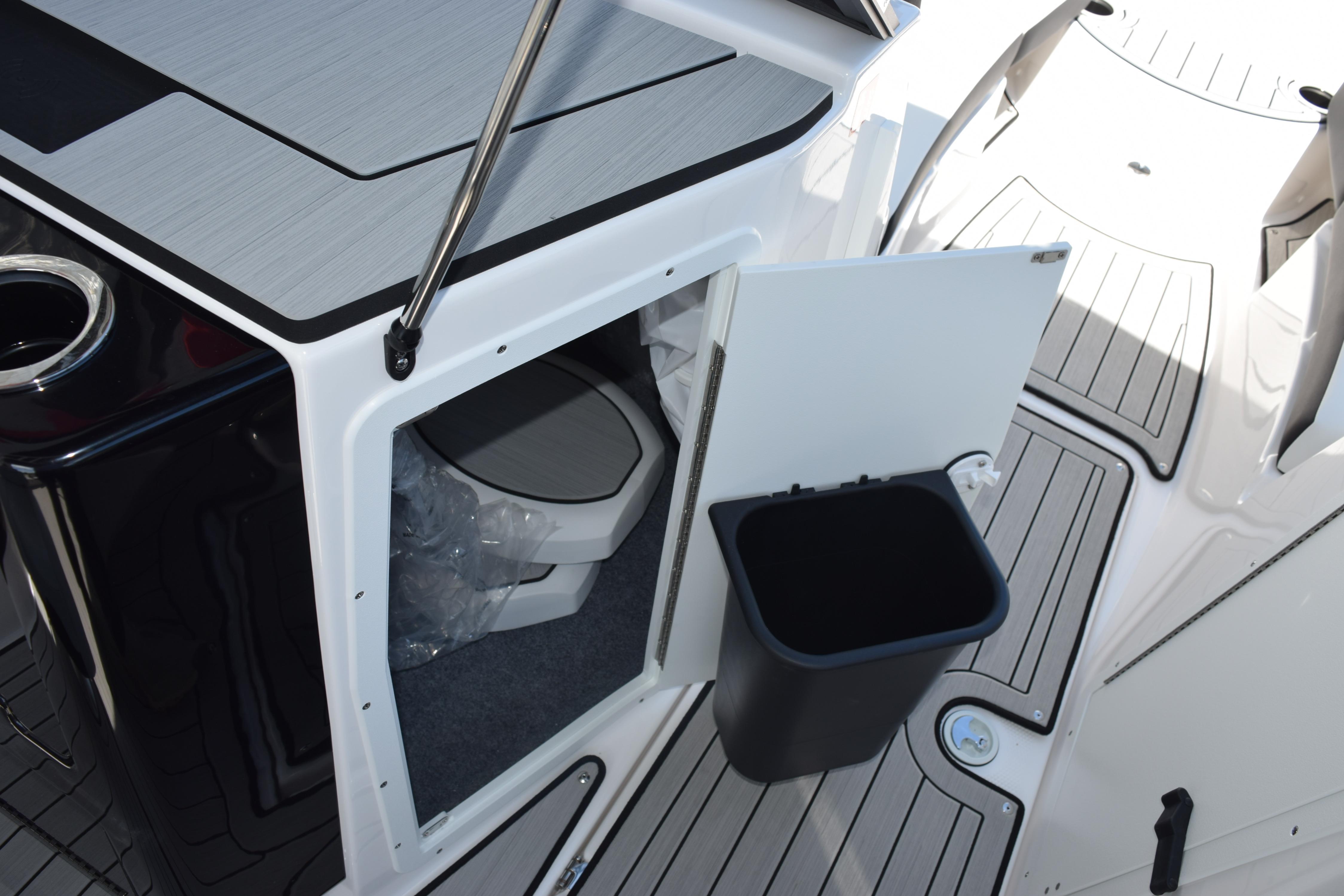 2026 Yamaha Boats 222SE interior with open storage compartment and trash bin.