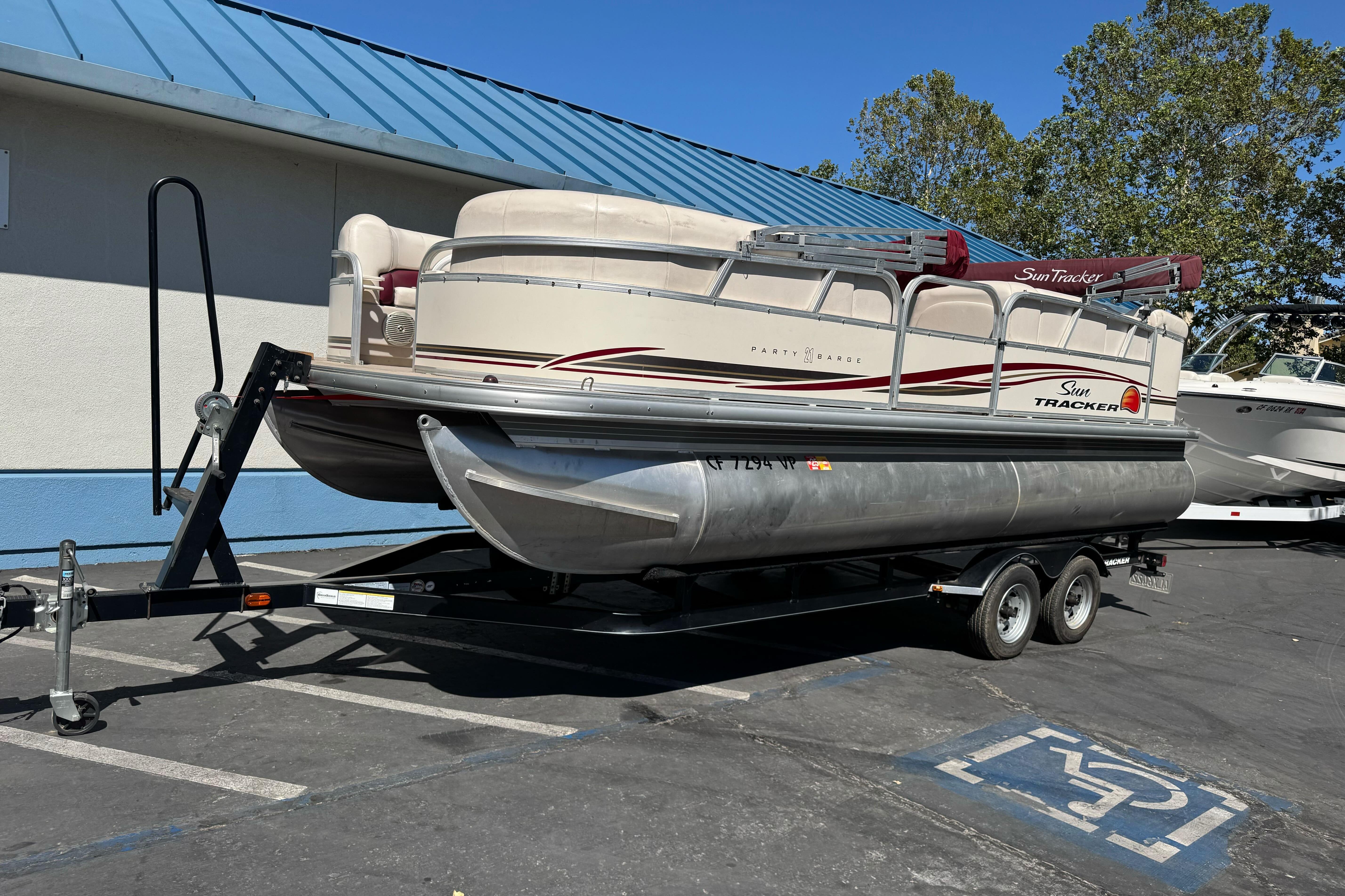2011 Sun Tracker Party Barge 21 pontoon boat on trailer in parking lot.