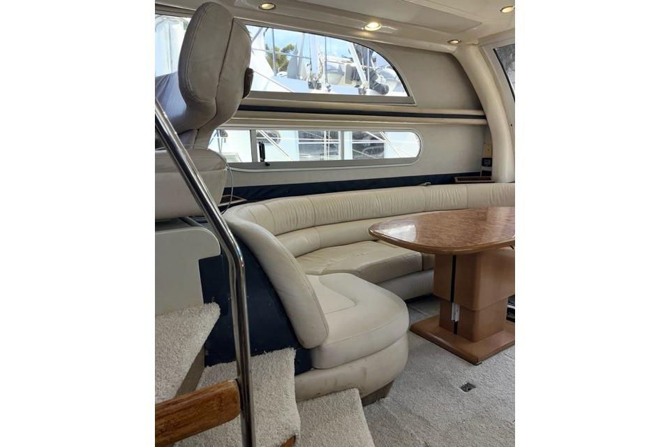 Interior of 1999 Sealine F44 yacht with plush seating and wooden table.