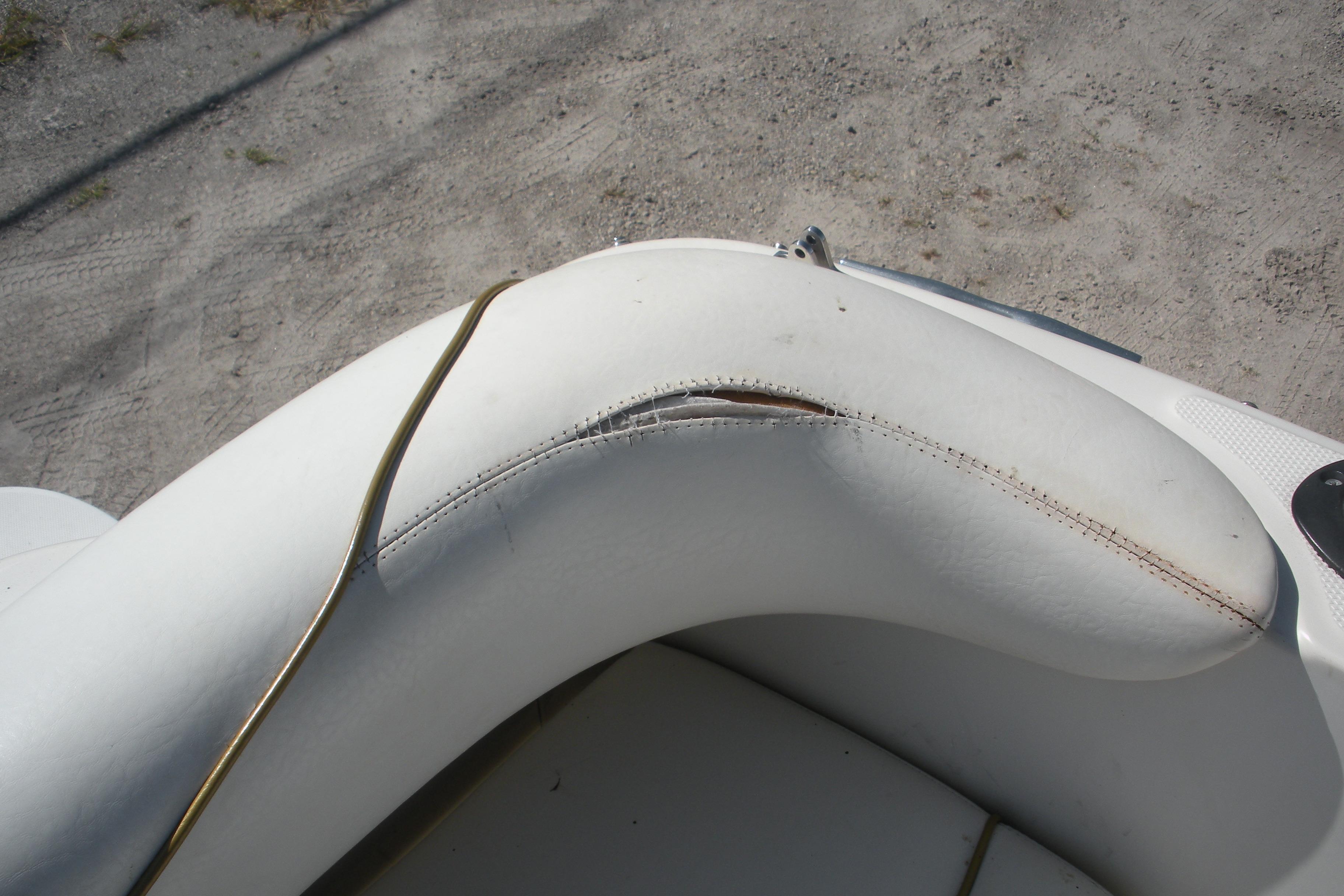 Torn white upholstery on 2000 Sea Ray 240 Sundancer boat seat.