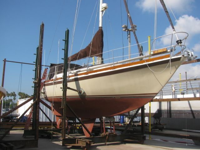 A sailboat in a dry dock, supported by metal frames.
