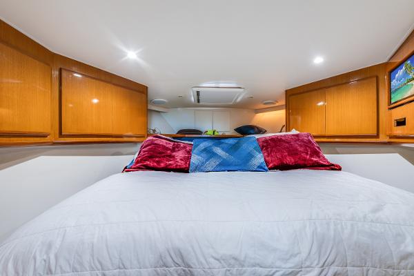 Luxurious bedroom interior of 1999 Viking 47 Convertible yacht with plush bedding.