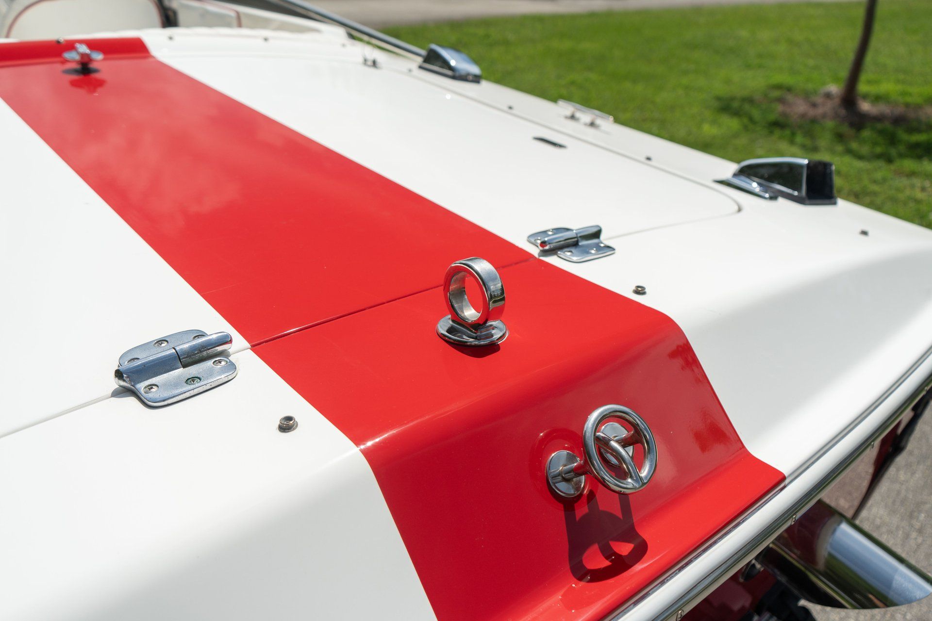 Close-up of a white 1995 Donzi Classic with a red stripe and metal fittings.