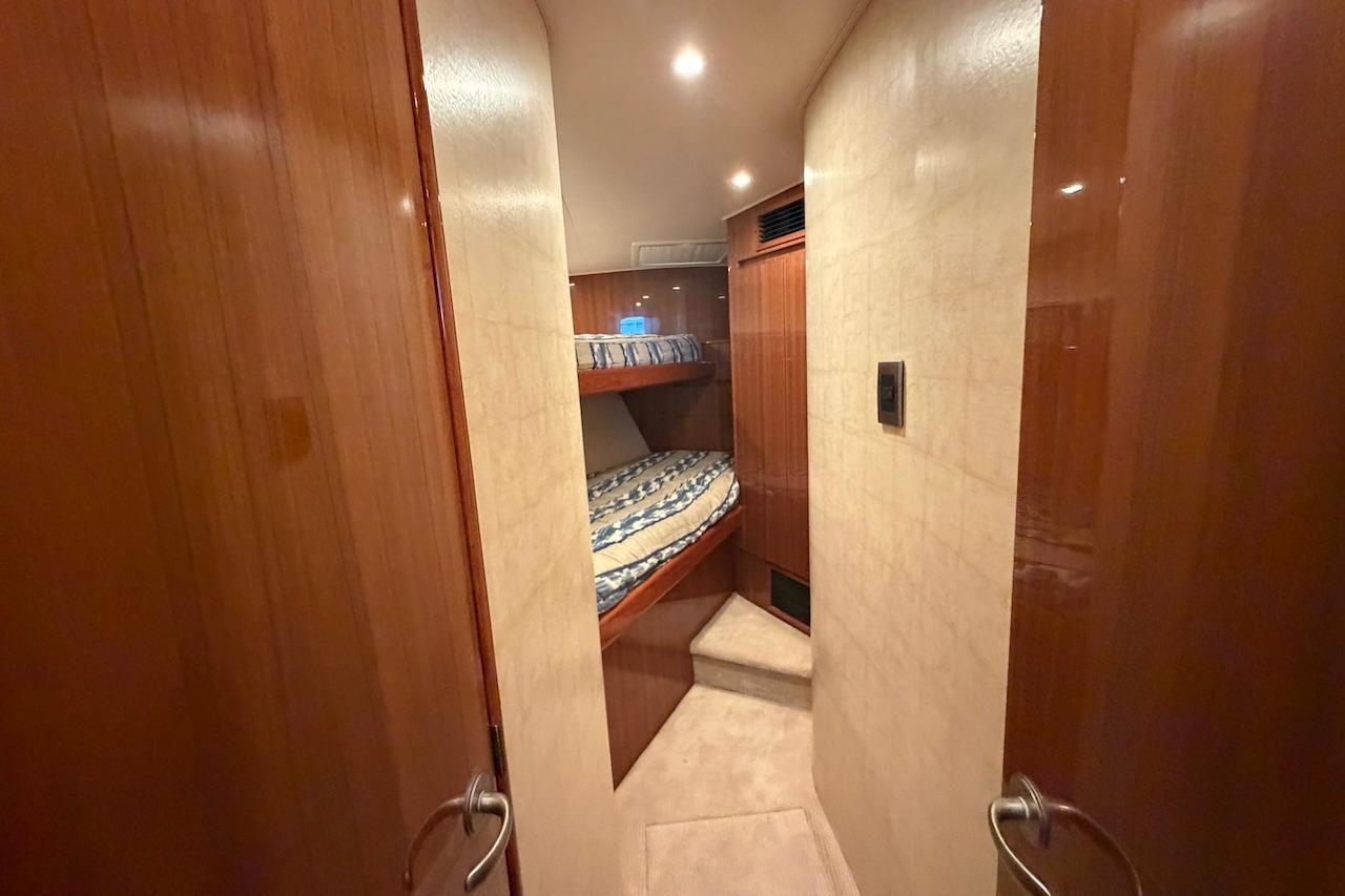 Interior cabin of 2012 Viking 50 Convertible yacht with bunk beds and wooden finish.