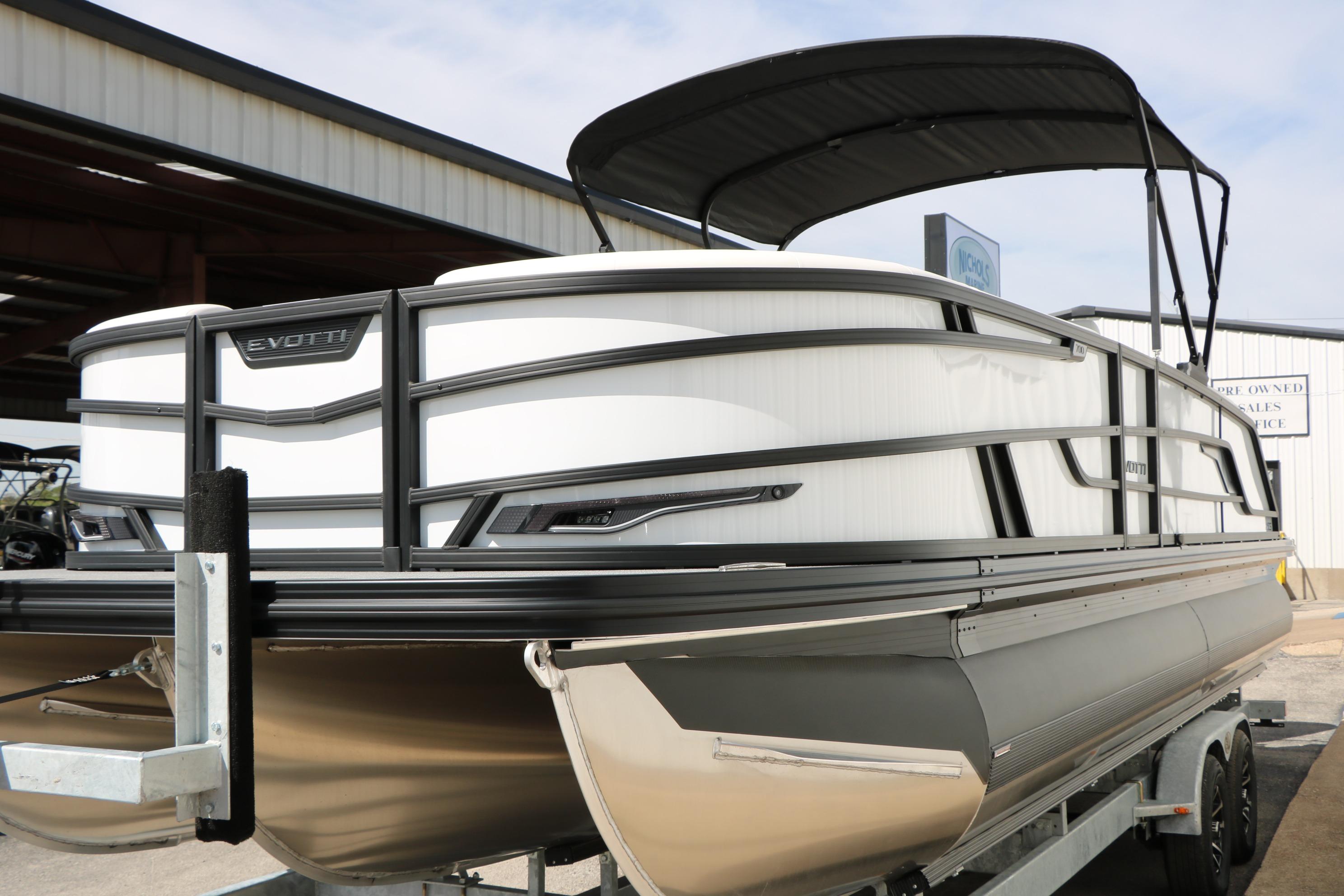 2026 Evotti 725 CS Tri-Toon boat with sleek design and canopy, displayed on a trailer.