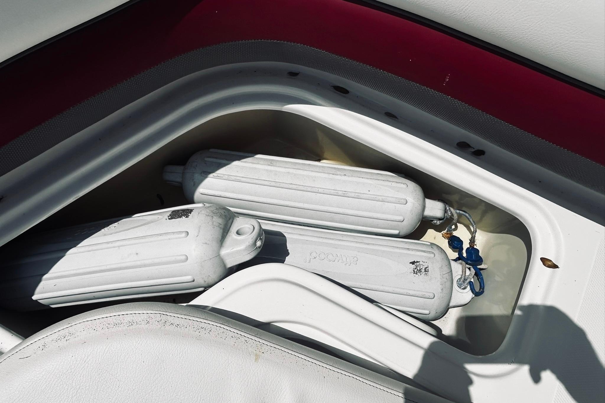 Storage compartment with boat fenders on a 2013 Hurricane SunDeck Sport 201 OB.