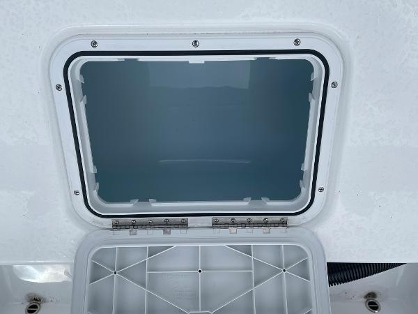 Open hatch on 2026 Cape Horn 24XS boat, showcasing interior compartment.