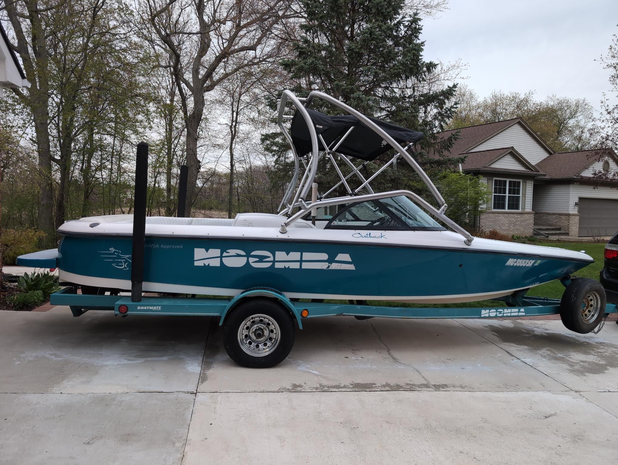 A 2000 Moomba Ouback LS boat on a trailer in a driveway.