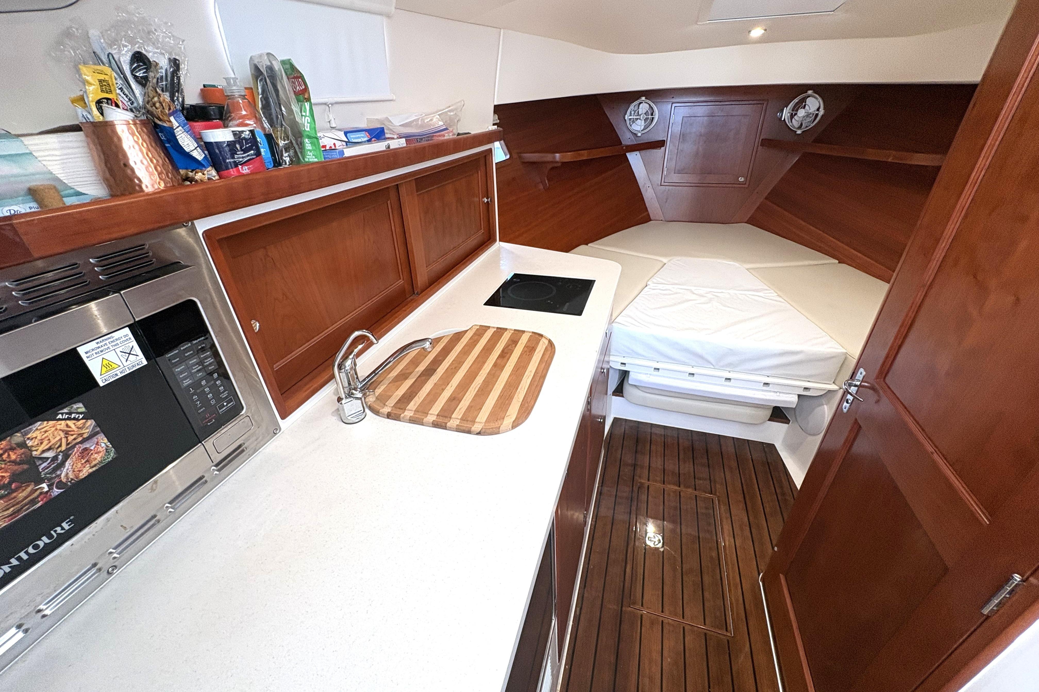 2024 MJM 35z yacht interior with kitchenette and cozy sleeping area.