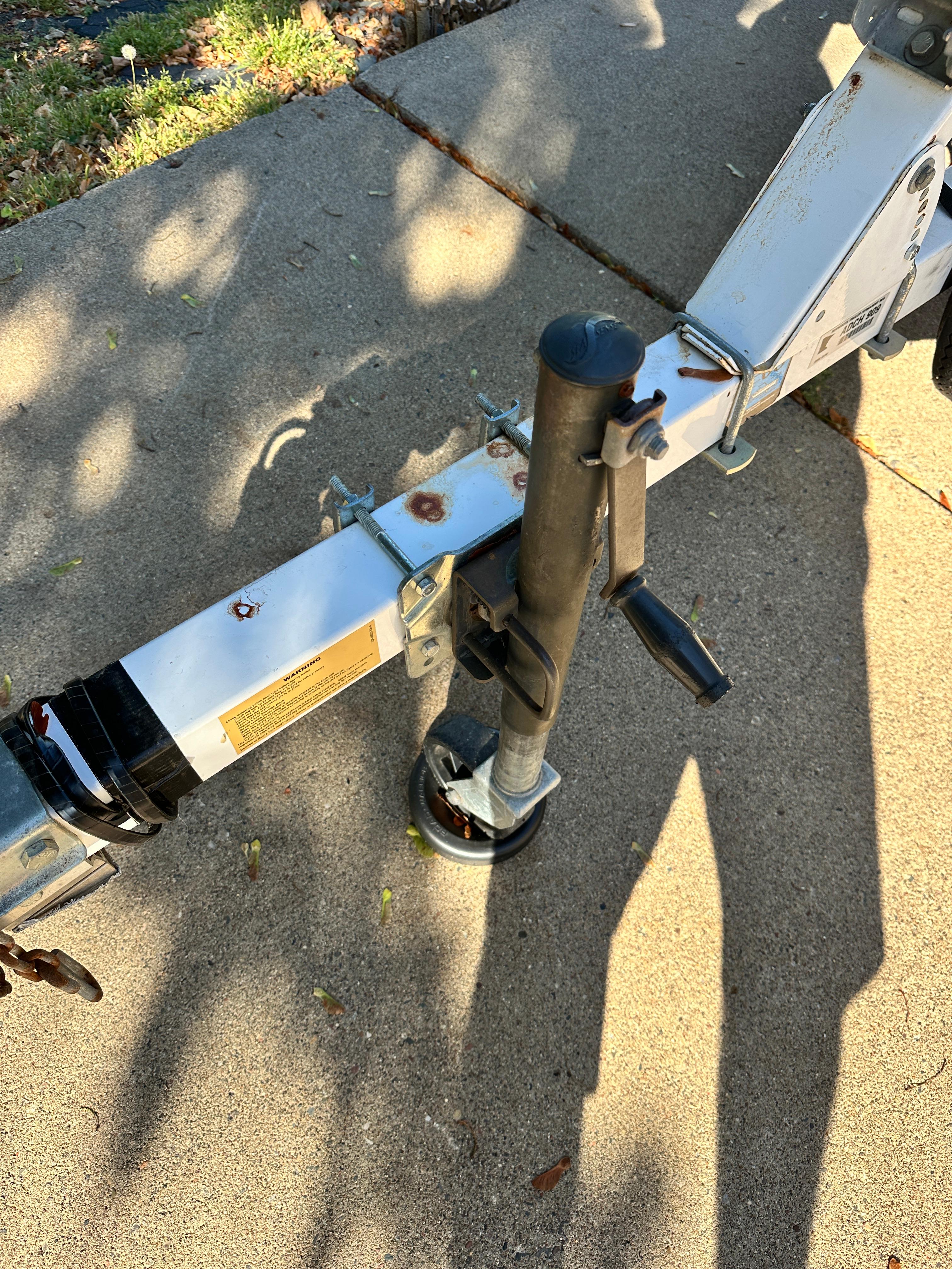 Trailer hitch and jack on a 1960 Lund H model, parked on concrete.