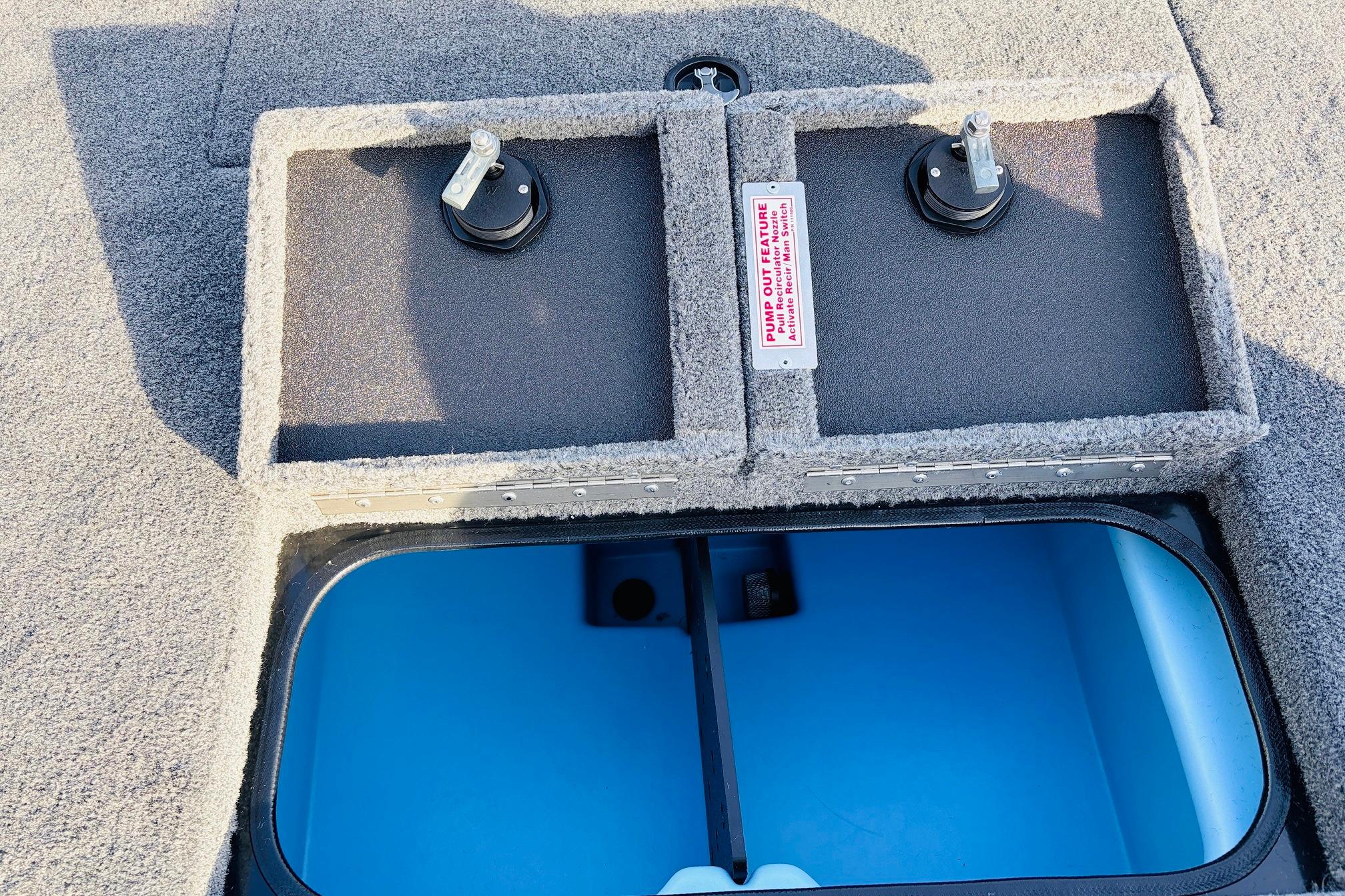 2025 Tracker Savage 215 boat storage compartment with pump-out feature and carpeted finish.