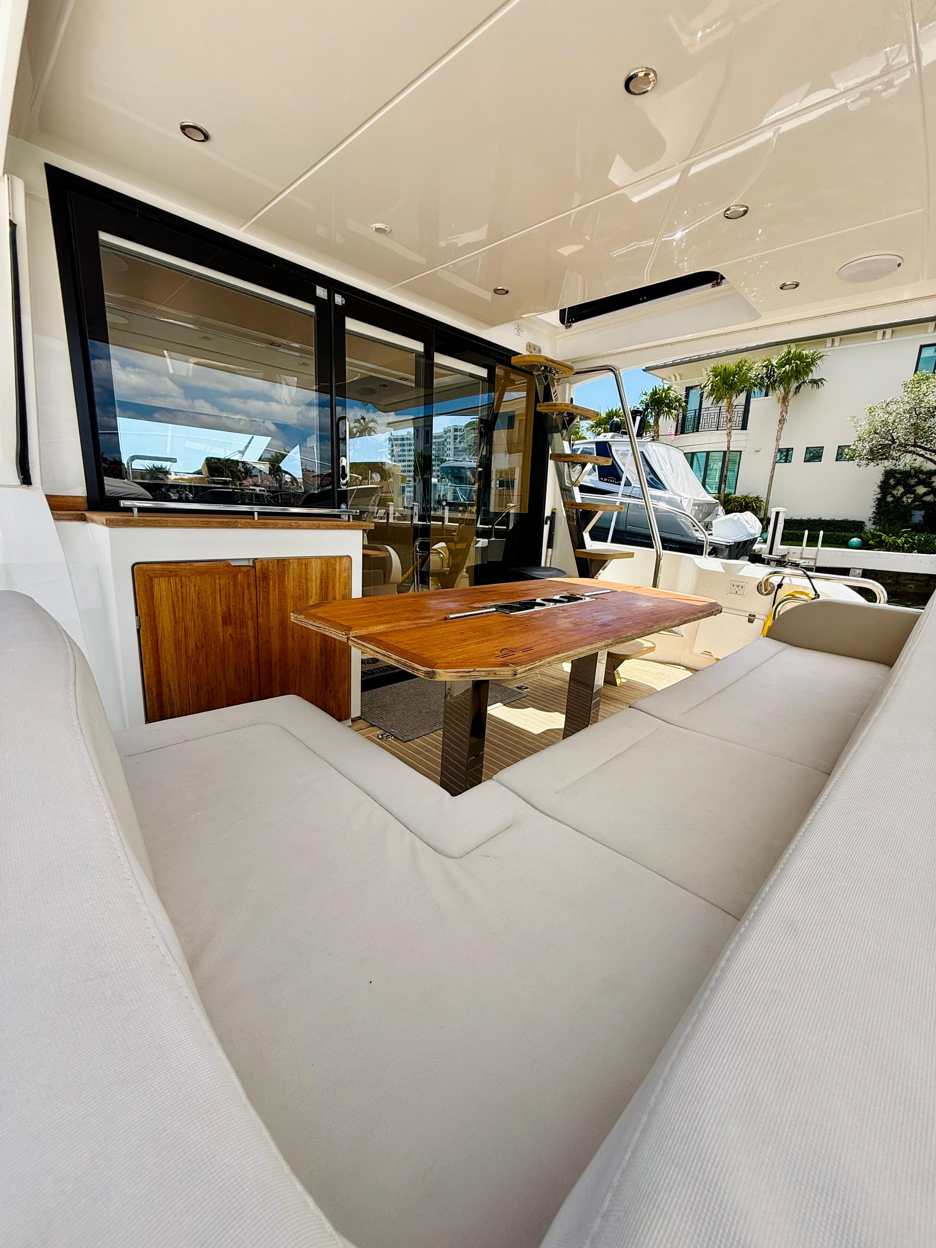 2019 Sealine F430 yacht interior with plush seating and wooden table.