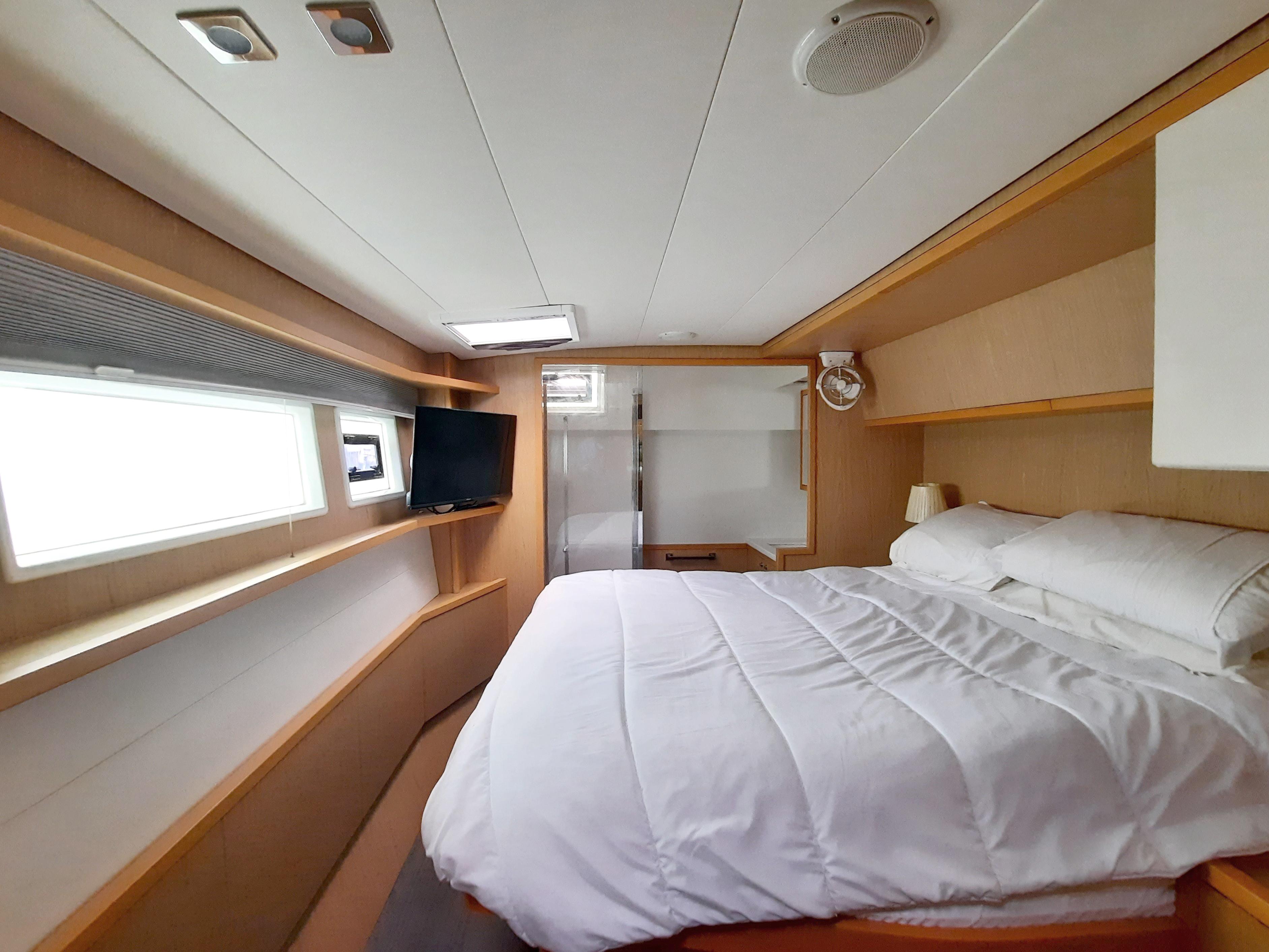Luxurious cabin interior of 2013 Lagoon 52 F yacht with cozy bed and modern amenities.