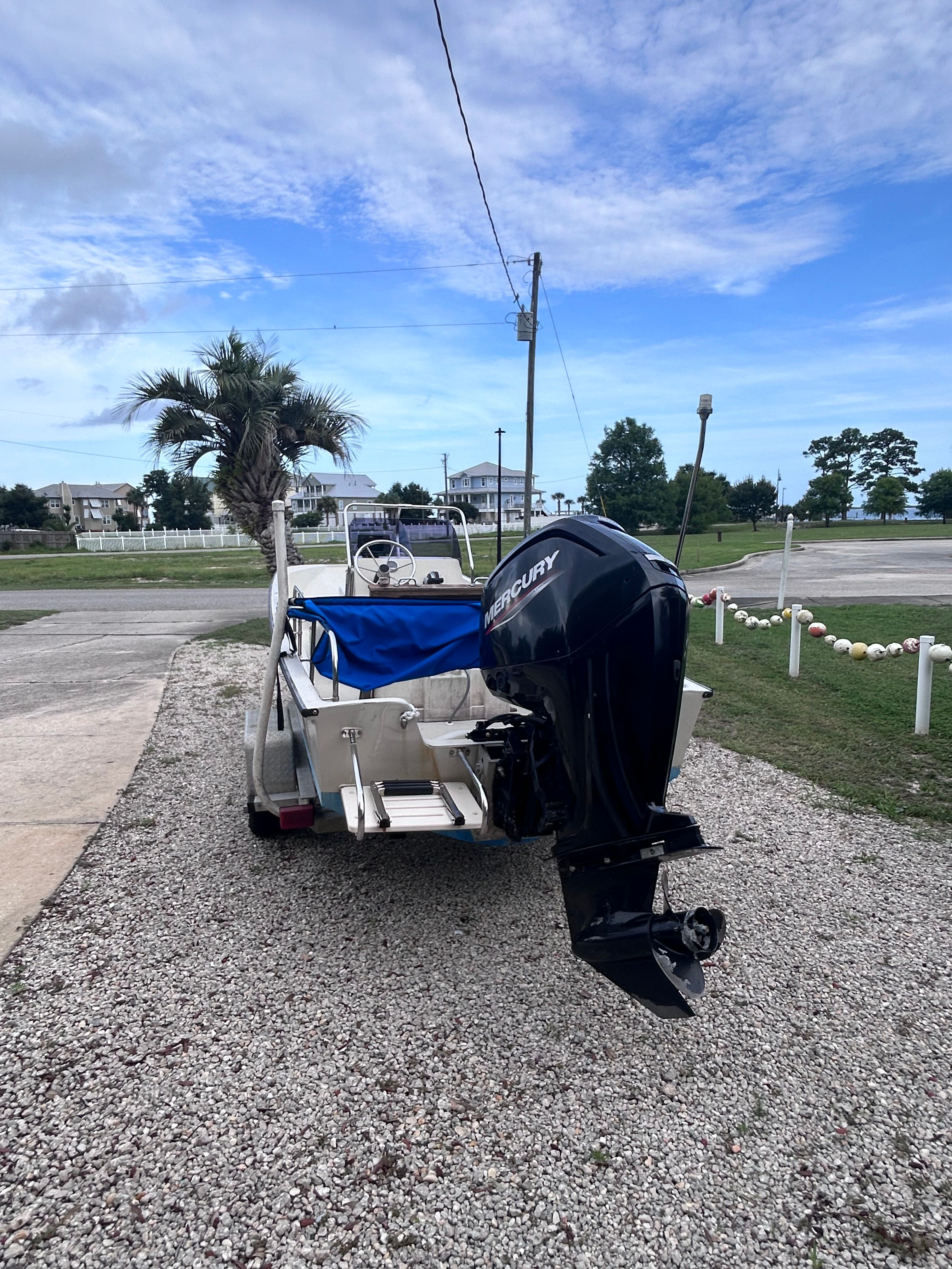 A 1984 Boston Whaler MONTAUK on a trailer on a gravel path.