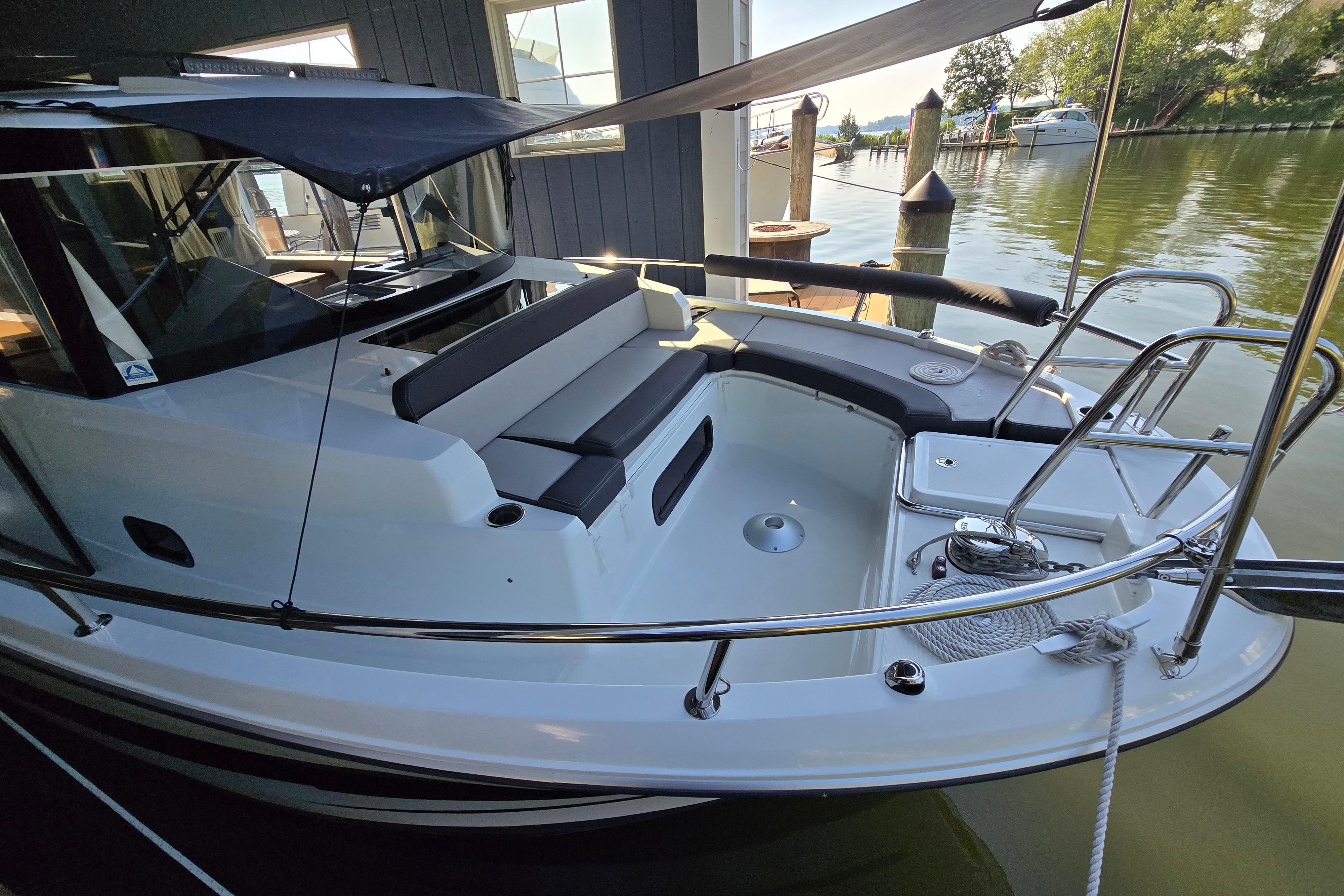 The boat is a 2023 Jeanneau NC Sport 895, docked at a marina.