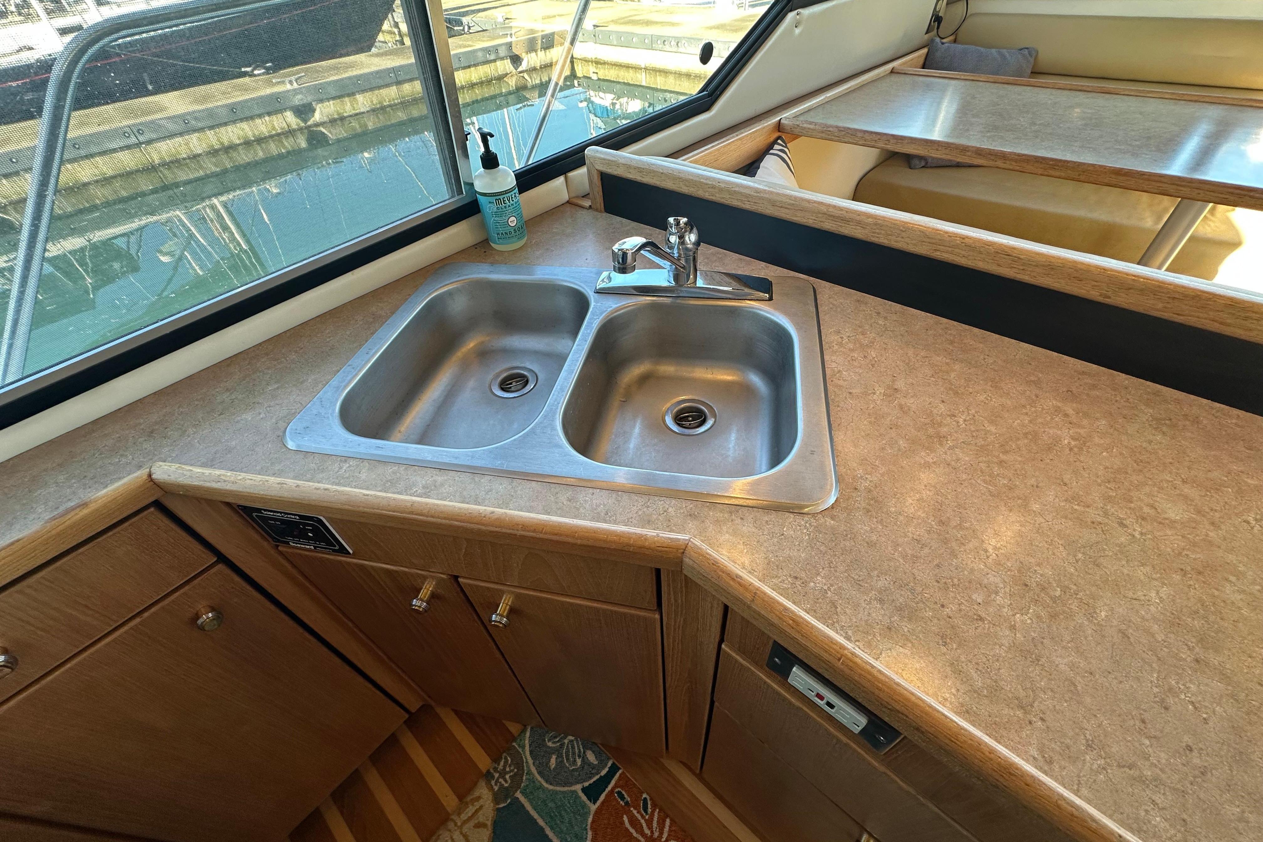Kitchen sink area in 2000 Bayliner 4087 Aft Cabin Motoryacht with countertop and window view.