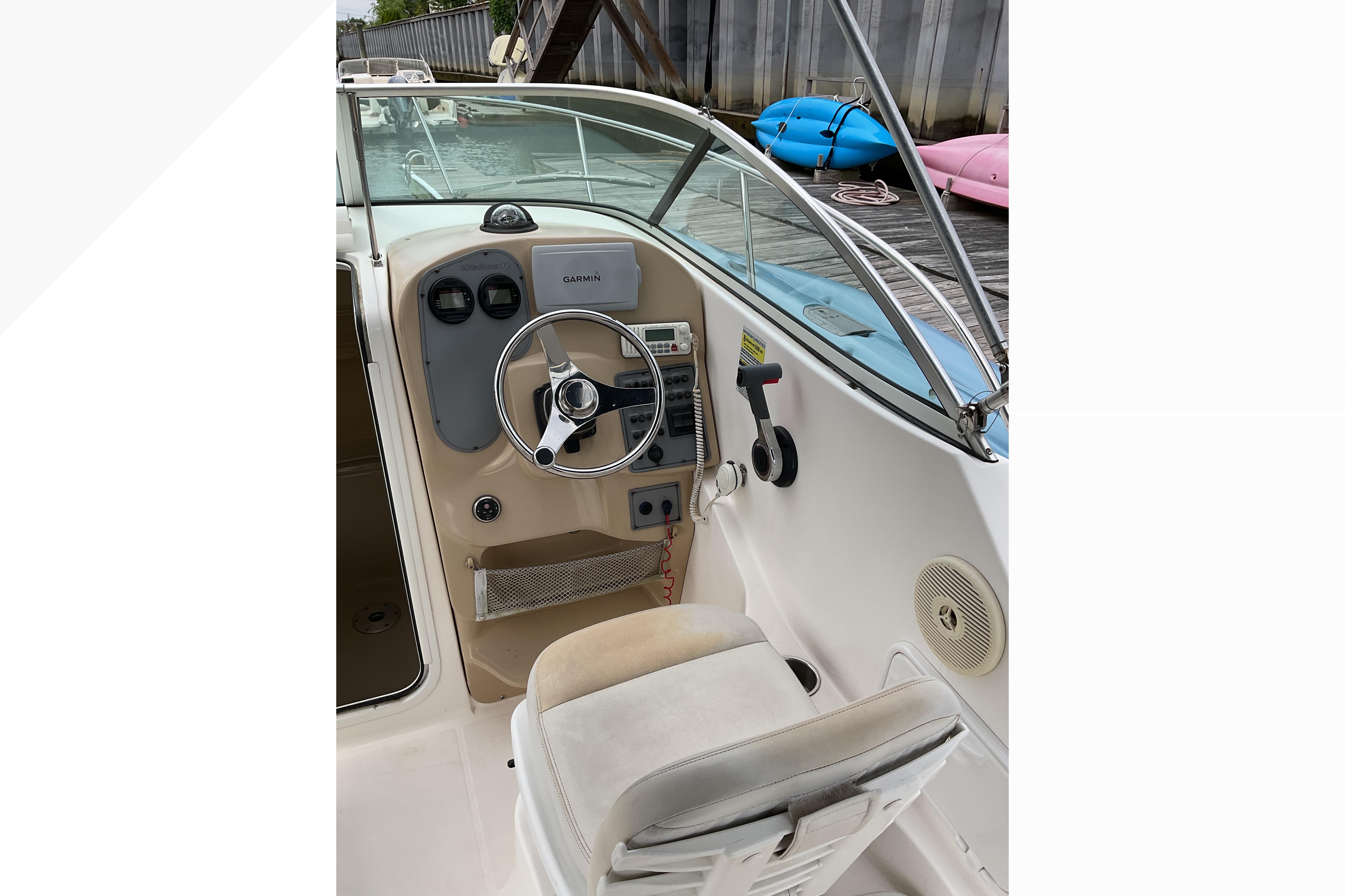 Interior view of 2012 Wellcraft 232 Coastal boat cockpit with steering wheel and controls.