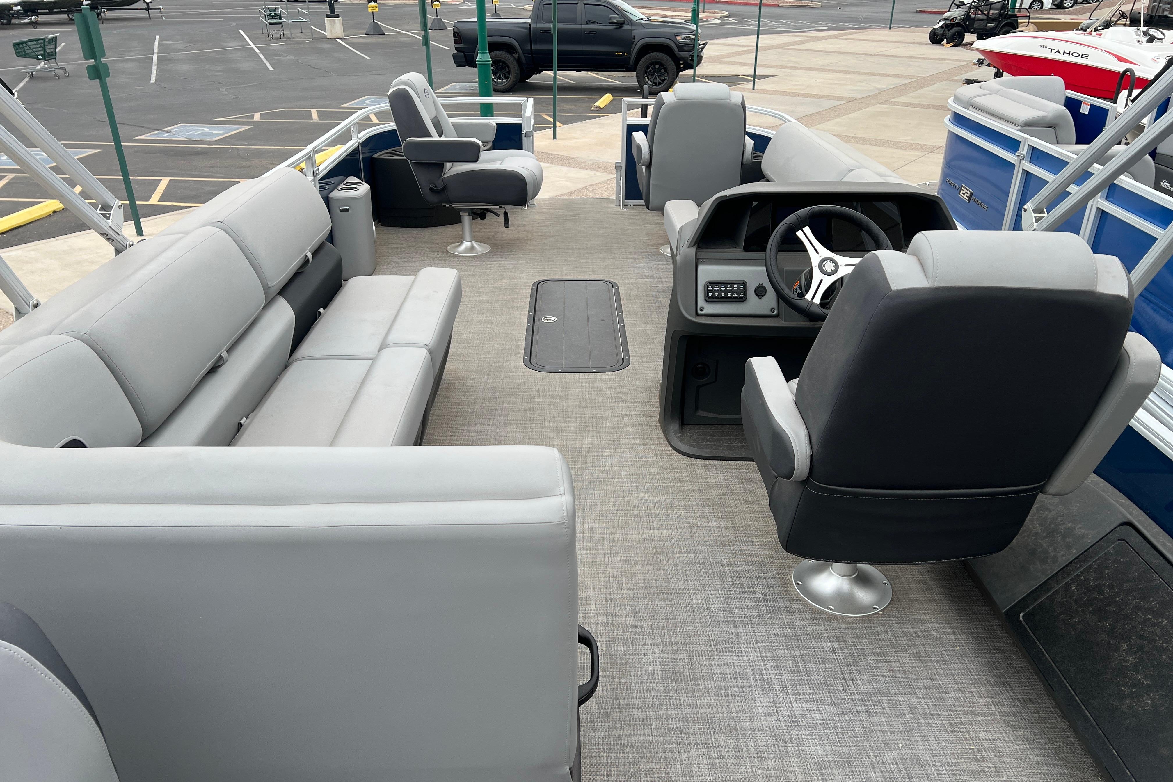 2026 Sun Tracker Sportfish 24 XP3 pontoon boat interior with gray seating and steering console.