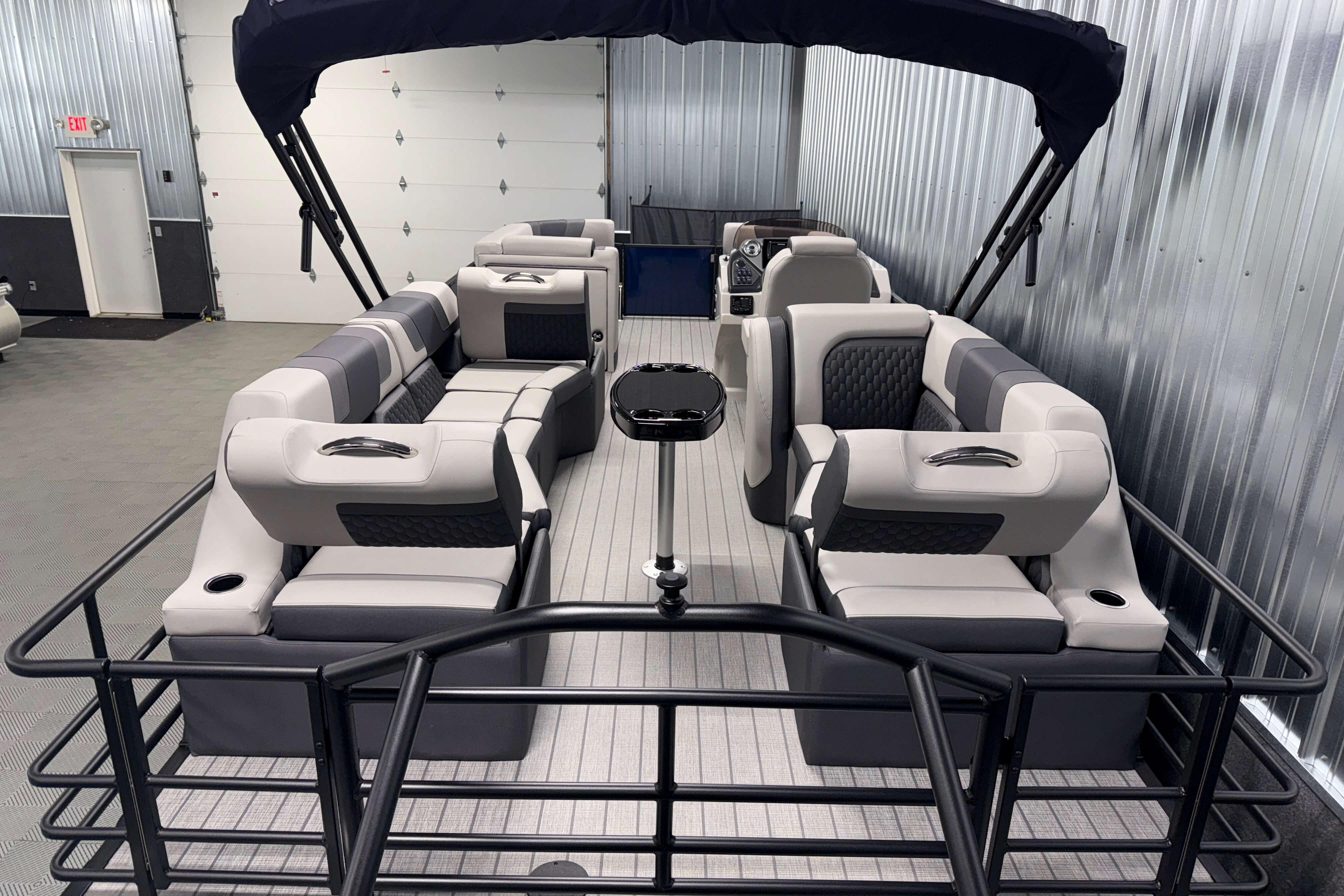 2026 Sylvan L3 SLZ pontoon boat with luxurious seating in a showroom.